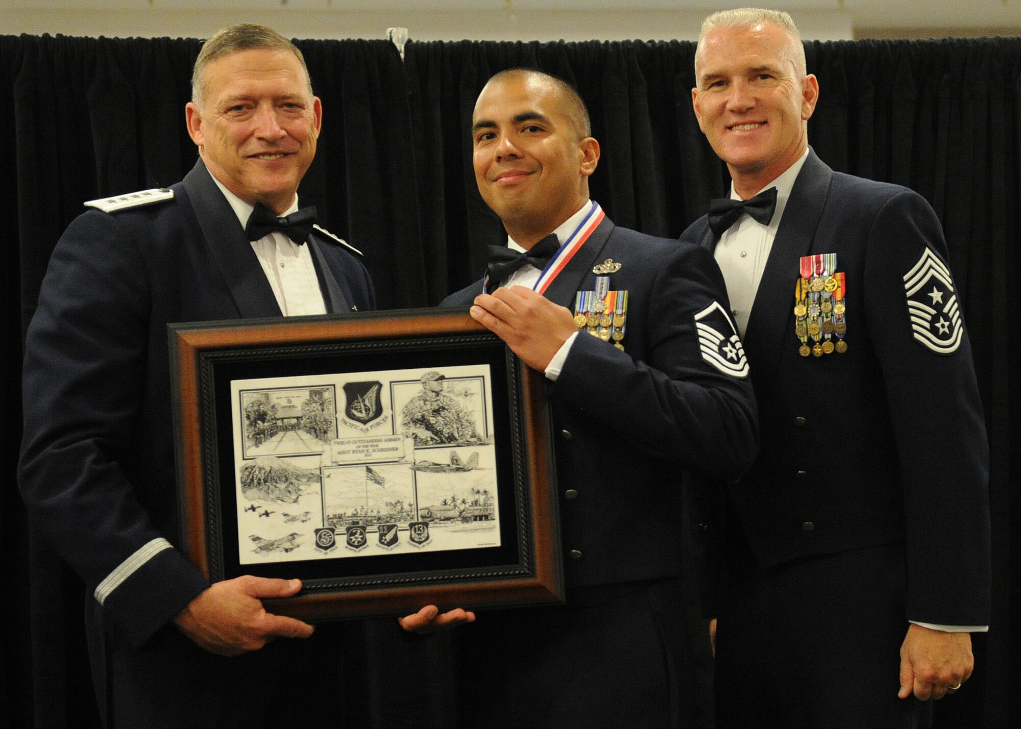 Pacific Air Forces commander Gen. Gary North and Chief Master Sgt. Brooke McLean, PACAF command chief, present Master Sgt. Ryan Schreiner, a security forces craftsman from 154th Security Forces Squadron, Joint Base Pearl Harbor-Hickam, Hawaii, with PACAF Outstanding Airman of the Year honors at the Tradewinds Enlisted Club, JBPH-H, Hawaii, April 27, 2012. (U.S. Air Force photo/Tech. Sgt. Jerome S. Tayborn)