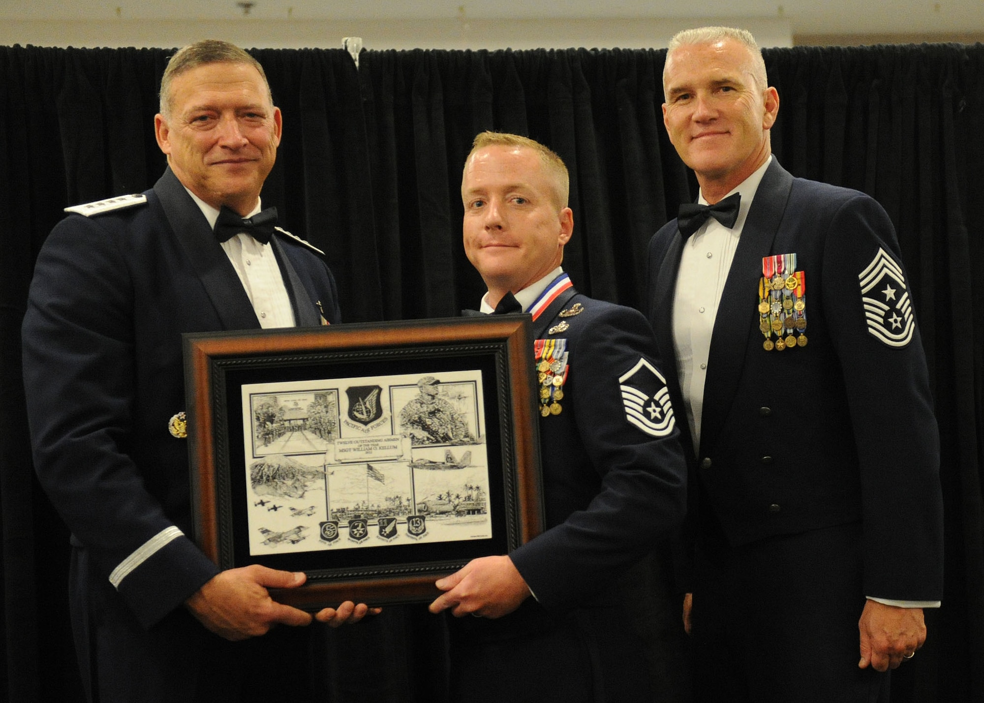 Pacific Air Forces commander Gen. Gary North and Chief Master Sgt. Brooke McLean, PACAF command chief, present Master Sgt. William Kellum, explosive ordnance disposal superintendent from the 354th Civil Engineering Squadron, Eielson Air Force Base, Alaska, with PACAF Outstanding Airman of the Year honors at the Tradewinds Enlisted Club, Joint Base Pearl Harbor-Hickam, Hawaii, April 27, 2012. (U.S. Air Force photo/Tech. Sgt. Jerome S. Tayborn)