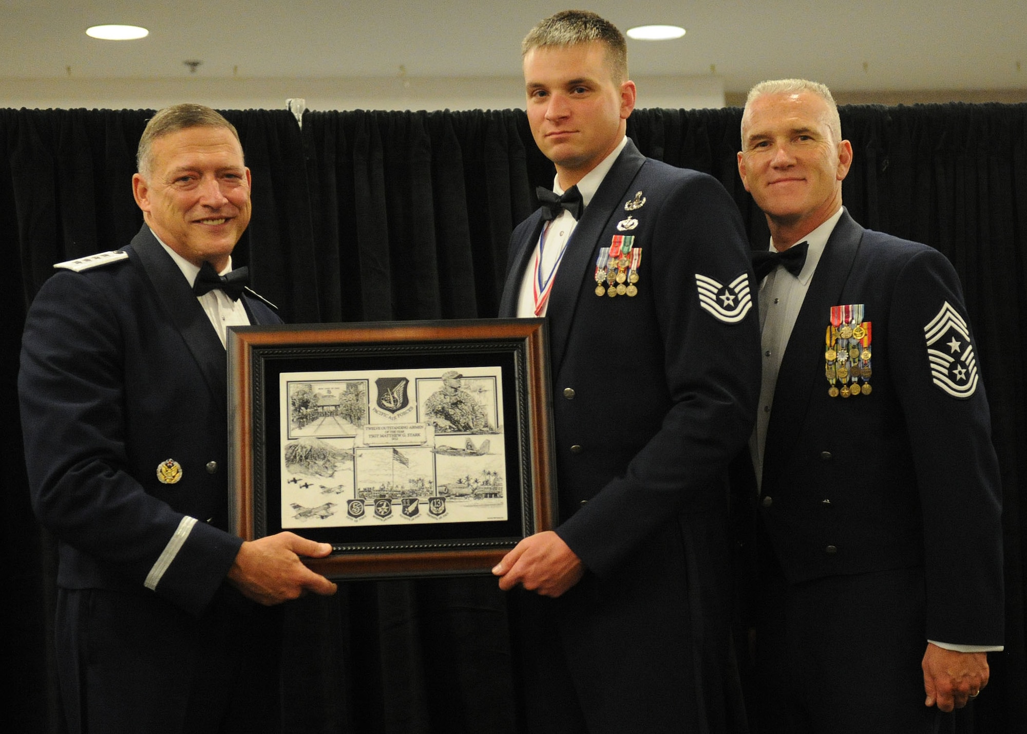 Pacific Air Forces commander Gen. Gary North and Chief Master Sgt. Brooke McLean, PACAF command chief, present Tech. Sgt. Matthew W. Stark, an explosive ordnance disposal craftsman from the 354th Civil Engineering Squadron, Eielson Air Force Base, Alaska, with PACAF Outstanding Airman of the Year honors at the Tradewinds Enlisted Club, Joint Base Pearl Harbor-Hickam, Hawaii, April 27, 2012. (U.S. Air Force photo/Tech. Sgt. Jerome S. Tayborn)