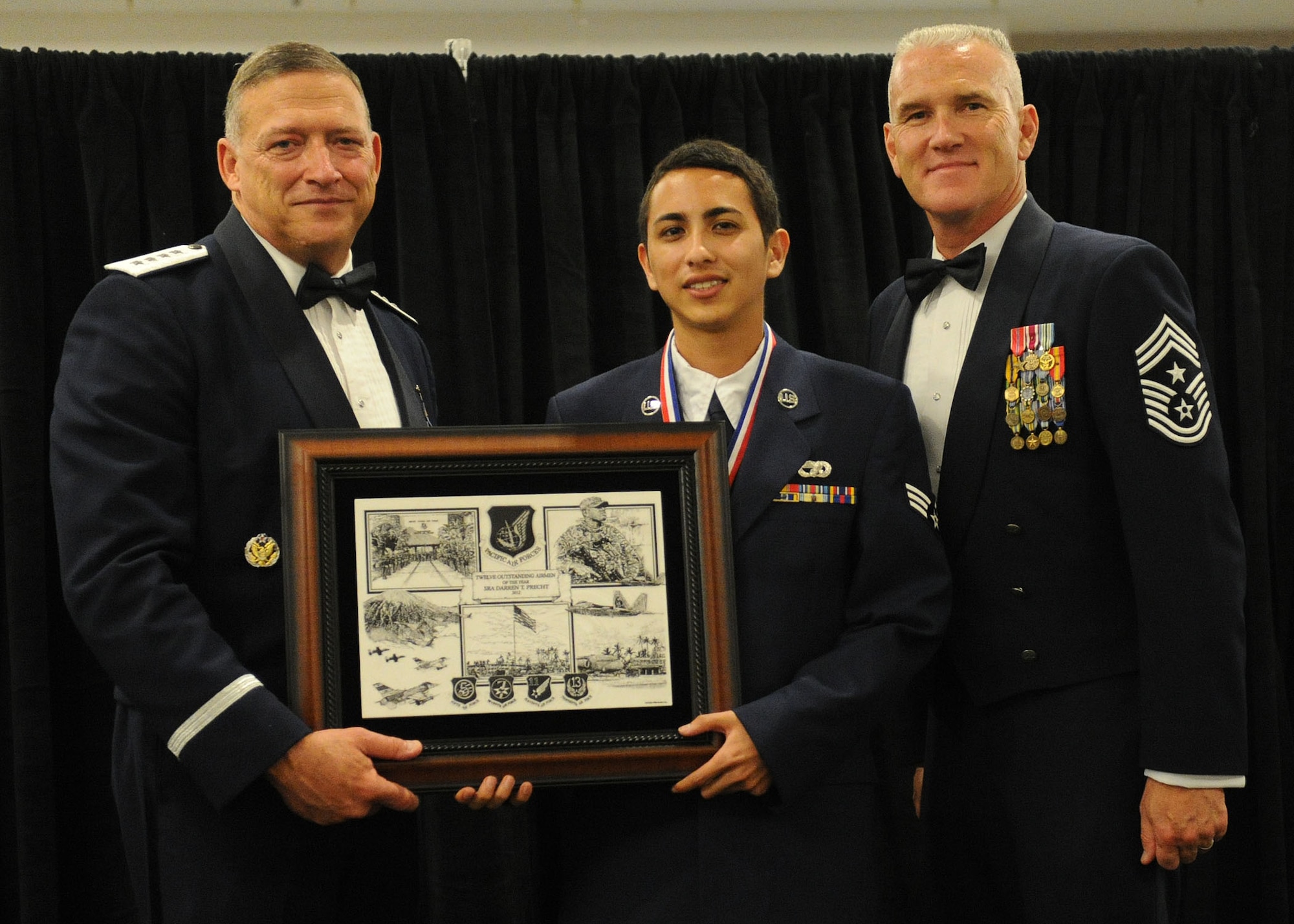 Pacific Air Forces commander Gen. Gary North and Chief Master Sgt. Brooke McLean, PACAF command chief, present Senior Airman Darren Precht, an air transportation journeyman from the 48th Aerial Port Squadron, Joint Base Pearl Harbor-Hickam, Hawaii, with PACAF Outstanding Airman of the Year honors at the Tradewinds Enlisted Club, JBPH-H, Hawaii, April 27, 2012. (U.S. Air Force photo/Tech. Sgt. Jerome S. Tayborn)