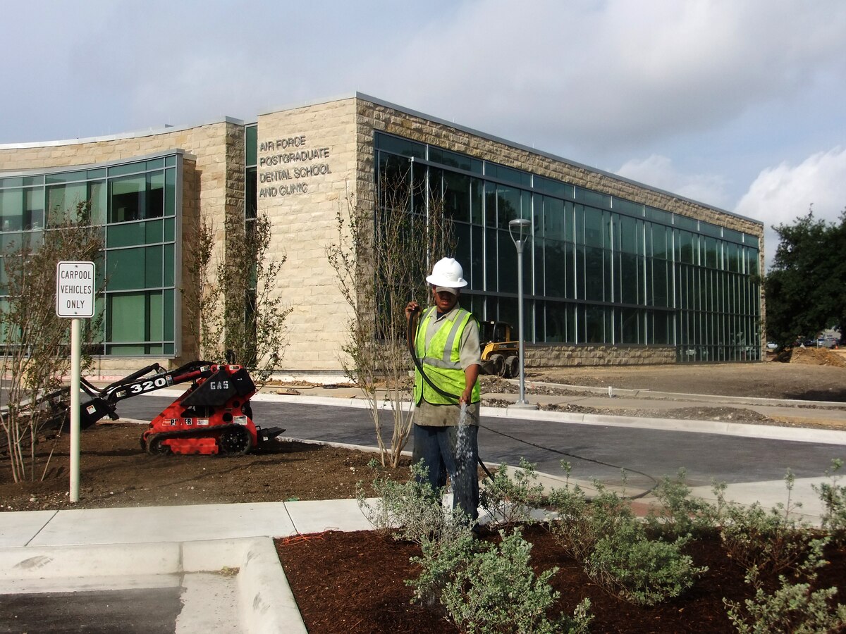 Workers lay the final touches and work to complete the landscape at the new Air Force Post Graduate Dental School and Clinic at Lackland Air Force Base, San Antonio, Texas, May 3, 2012.  The building is a $38 million project that began in 2010 and has now opened its doors to start receiving patient. (U.S. Air Force Photo/Linda Frost)