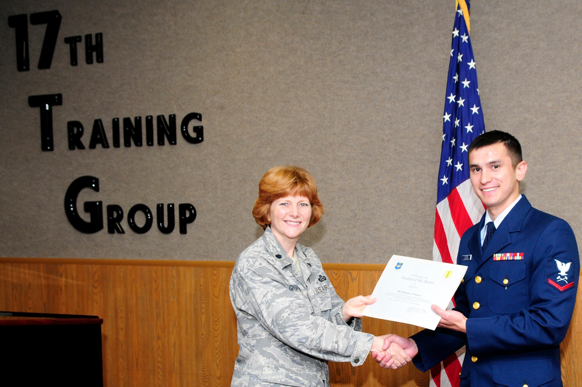 GOODFELLOW AIR FORCE BASE, Texas – Lt. Col. Patricia Griffin, 17th Training Group Deputy Commander, presents Coast Guard Petty Officer 3rd Class Randy J. Powers with the 312th Training Squadron Student of the Month award for April, May 4. (U.S. Air Force photo/Staff Sgt. Austin Knox)