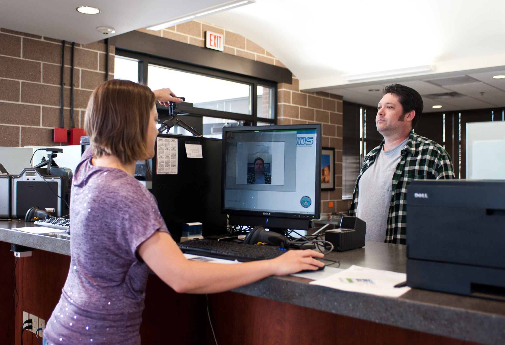 Pamela Carpino, 28th Security Forces Squadron Visitor Control Center pass and registration clerk, takes a picture of Aaron Hill, Skyline Engineering contractor for his visitor’s pass at Ellsworth Air Force Base, S.D., May 3, 2012.The VCC is responsible for ensuring proper identification and background checks are performed to help guarantee the safety and security of the base. (U.S. Air Force photo by Airman 1st Class Alystria Maurer/Released)