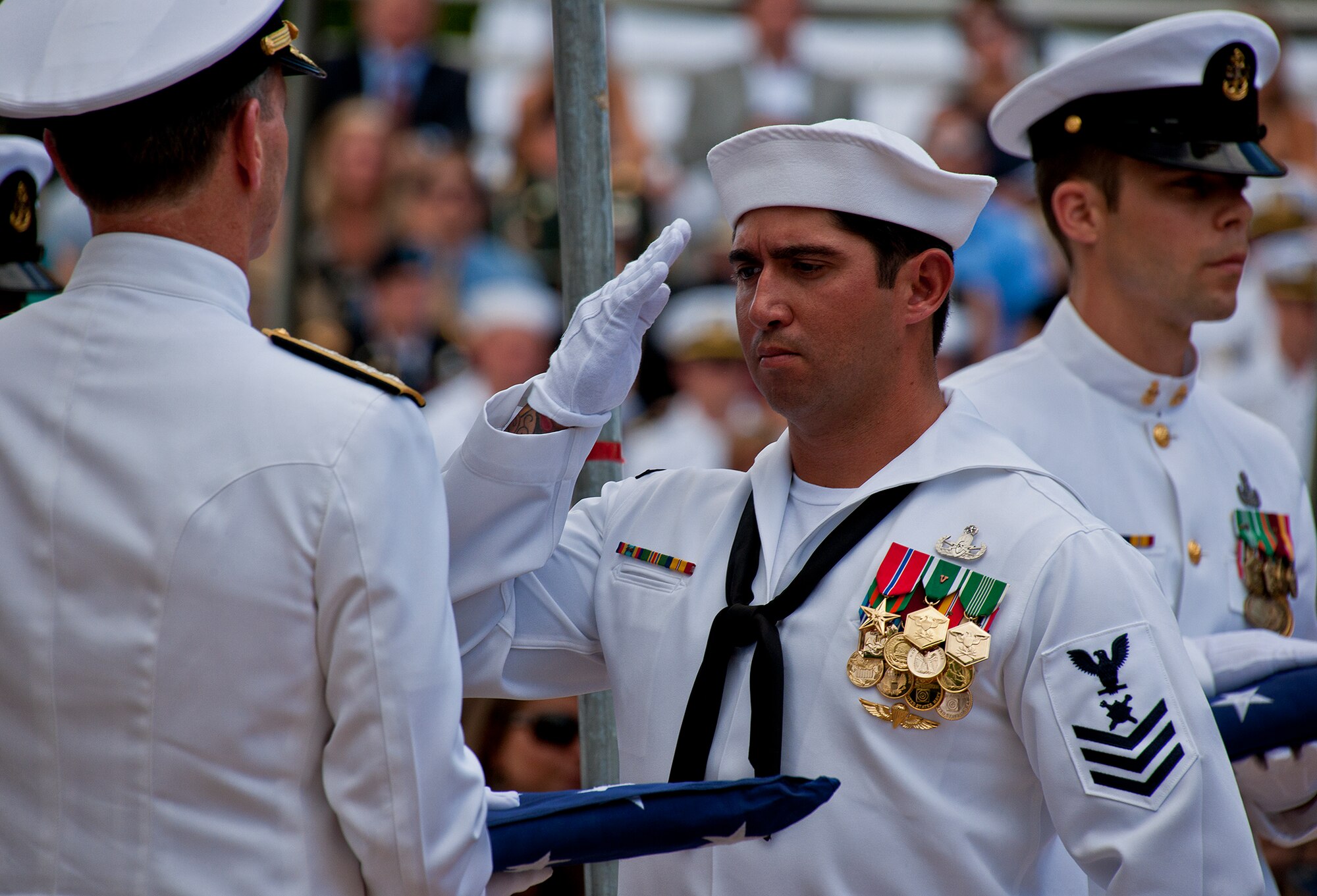A Petty Officer 1st Class salutes after handing off a folded flag during the 43rd Annual EOD Memorial Ceremony May 5, 2012, at Eglin Air Force Base, Fla.  (U.S. Air Force photo/Samuel King Jr.)