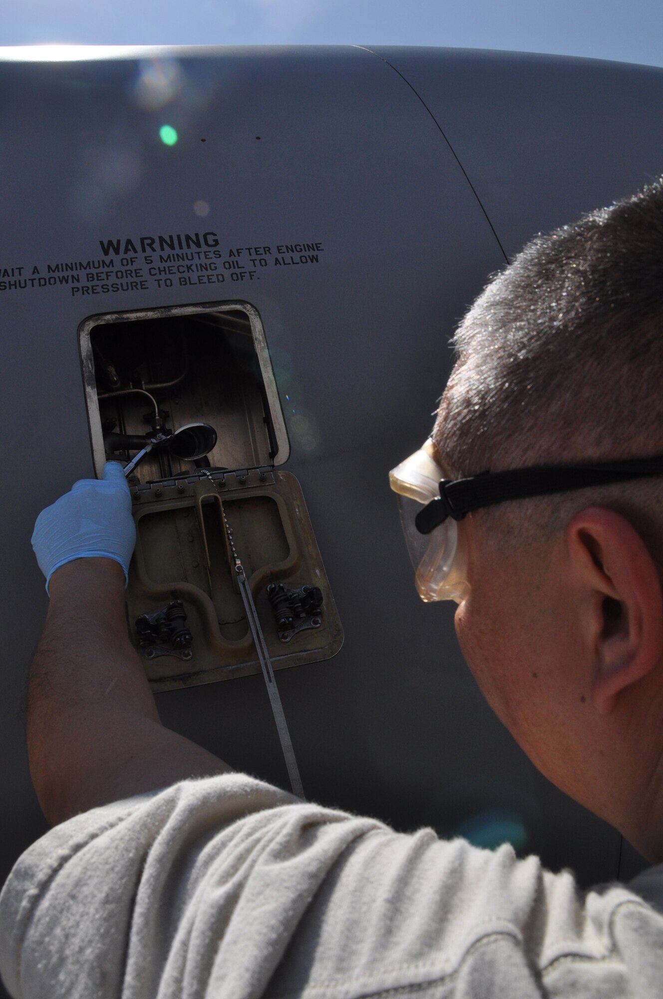 Staff Sgt. Steve Lopez, aircraft maintainer, 931st Aircraft Maintenance Squadron, uses an inspection mirror to check the engine oil on a KC-135 Stratotanker following an employer flight, May 5. (Air Force photo by Tech. Sgt. Brannen Parrish)