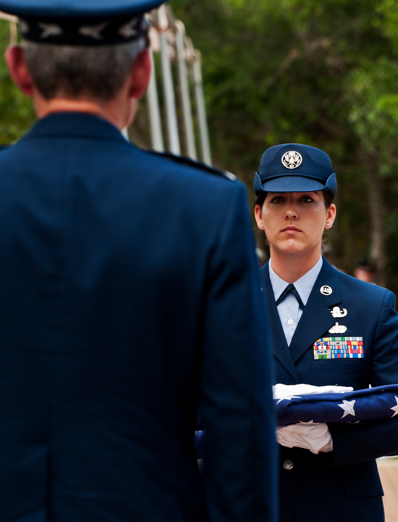 Staff Sgt. Sarah Snyder, of the 366th Training Squadron Det. 3, brings Air Force Chief of Staff Gen. Norton Schwartz a folded flag to present to a family member of a fallen explosive ordnance disposal Airman during the annual EOD Memorial Ceremony May 5, 2012, at Eglin Air Force Base, Fla. Schwartz was the guest speaker at the event that honored 18 EOD technicians, five of which were Airmen.  With the new names added, there are now 287 names inscribed on the memorial wall.  (U.S. Air Force photo/Samuel King Jr.)