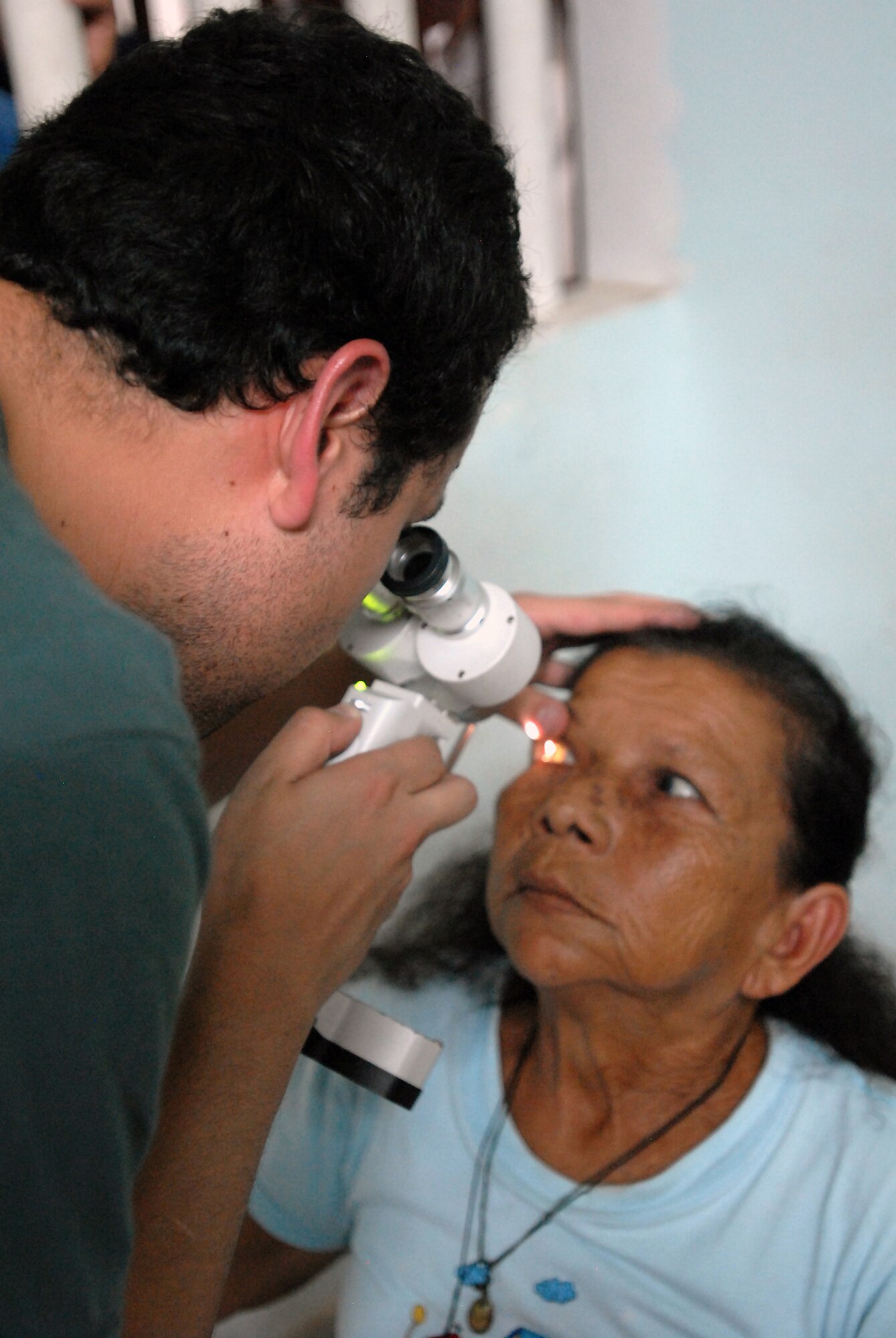 120427-A-WP252-008- Dr. Diego A. Rodriguez, a volunteer ophthalmologist, uses a slit lamp to check the eyes of an elderly woman as part of a two-day Surgical Civic Action Program April 27-28 in the small town of La Macarena, Colombia, located 170 miles southeast of Bogota. The ophthalmologist was one of 30 volunteers who gave his time to “Patrulla Aerea Civil Colombiana” or PAC, a Bogota-based nongovernment medical organization that provides medical services to several remote communities across Colombia.  