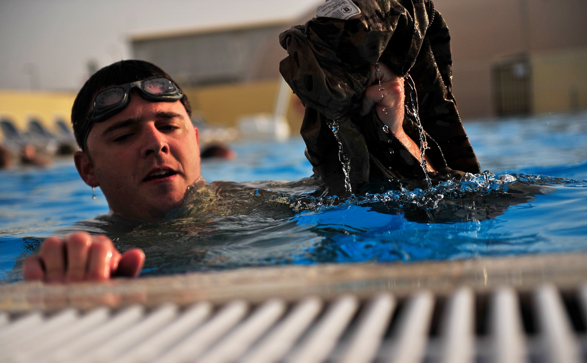 SOUTHWEST ASIA - U.S. Air Force Capt. John Fuson, 380th Expeditionary Civil Engineer Squadron Explosive Ordnance Disposal officer in charge, removes his uniform top during water training in Southwest Asia May 3, 2012. Fuson and members of the EOD flight swim as part of their training routine to stay in top physical condition. (U.S. Air Force photo/Staff Sgt. Sara Csurilla)