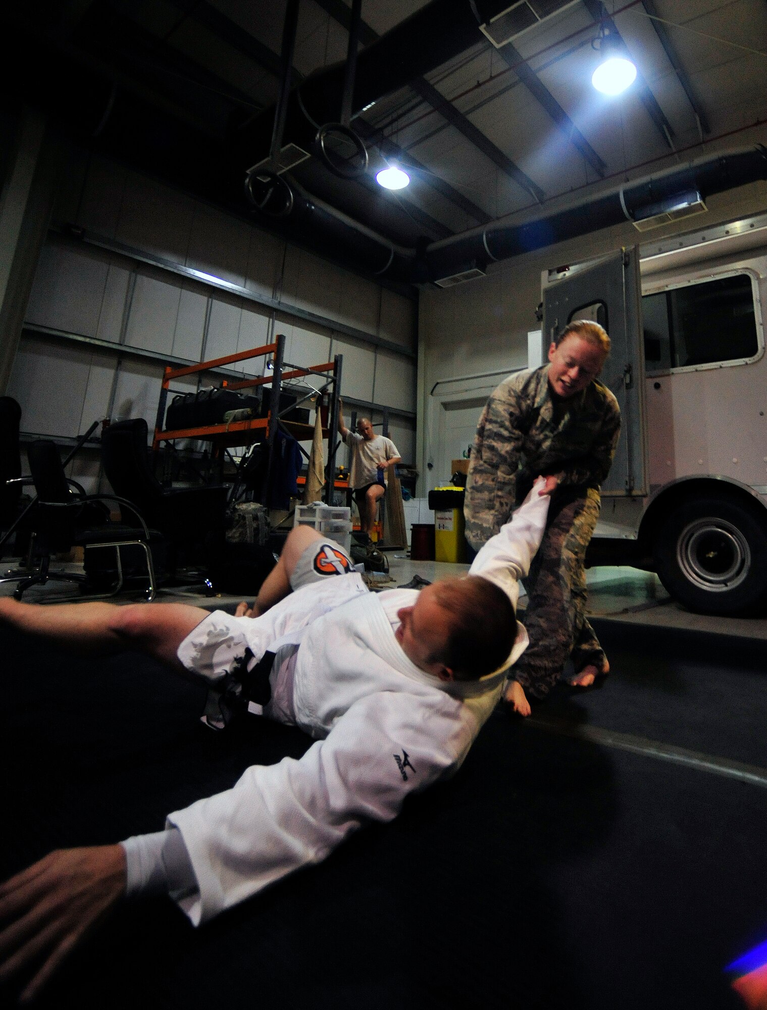 U.S. Air Force Staff Sgt. Jessica Lafo flips Staff Sgt. Anthony Walling, both 380th Expeditionary Civil Engineer Squadron Explosive Ordnance Disposal technicians, during combatives training at the 380th Air Expeditionary Wing May 6, 2012. Members of the EOD flight use combatives training, CrossFit and water survival training as part of their routine to stay in top physical condition. (U.S. Air Force photo/Staff Sgt. Sara Csurilla)