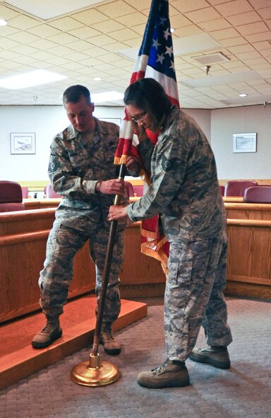 Master Sgt. Eric Mendez, left, and Tech. Sgt. Vivianne Yazzie-Williams, 28th Bomb Wing Protocol Office protocol specialists, place the American flag in its proper position in the 28th BW Headquarters wing conference room at Ellsworth Air Force Base, S.D., April 26, 2012. The Protocol Office oversees a vast array of military functions. (U.S. Air Force photo by Airman 1st Class Anania Tekurio/Released)