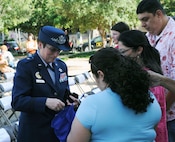 Brig. Gen. Theresa C. Carter, Joint Base San Antonio commander, hands out Fiesta medals during the El Rey Feo coronation April 20. (U.S. Air Force Photo by Don Lindsey)