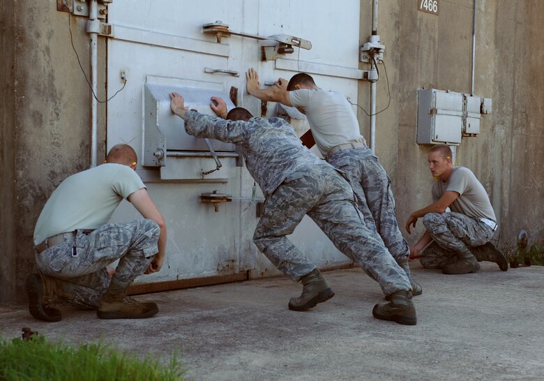 Airmen from the 2nd Munitions Squadron secure the door to a munitions storage facility on Barksdale Air Force Base, La., May 4. The storage facilities are specifically designed to house explosive materials and would contain an explosion in the event of an unintentional detonation. (U.S. Air Force photo/Airman 1st Class Benjamin Gonsier)(RELEASED)