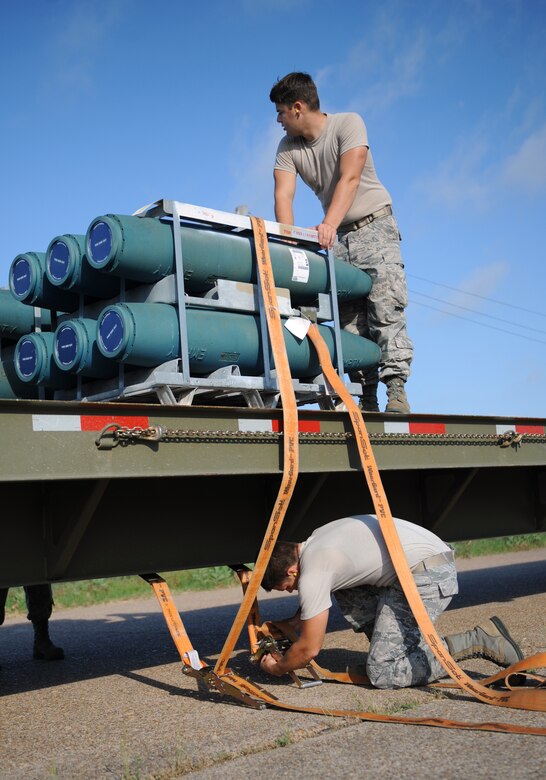 Airman 1st Class Shane Shriner, above, and Staff Sgt. Chris Howard, 2nd Munitions Squadron storage and handling, secure bombs on the back of a trailer on Barksdale Air Force Base, La., May 4. The bombs were tightly secured before 2 MUNS storage and handling Airmen transported them to a bomb-building facility. (U.S. Air Force photo/Airman 1st Class Benjamin Gonsier)(RELEASED) 