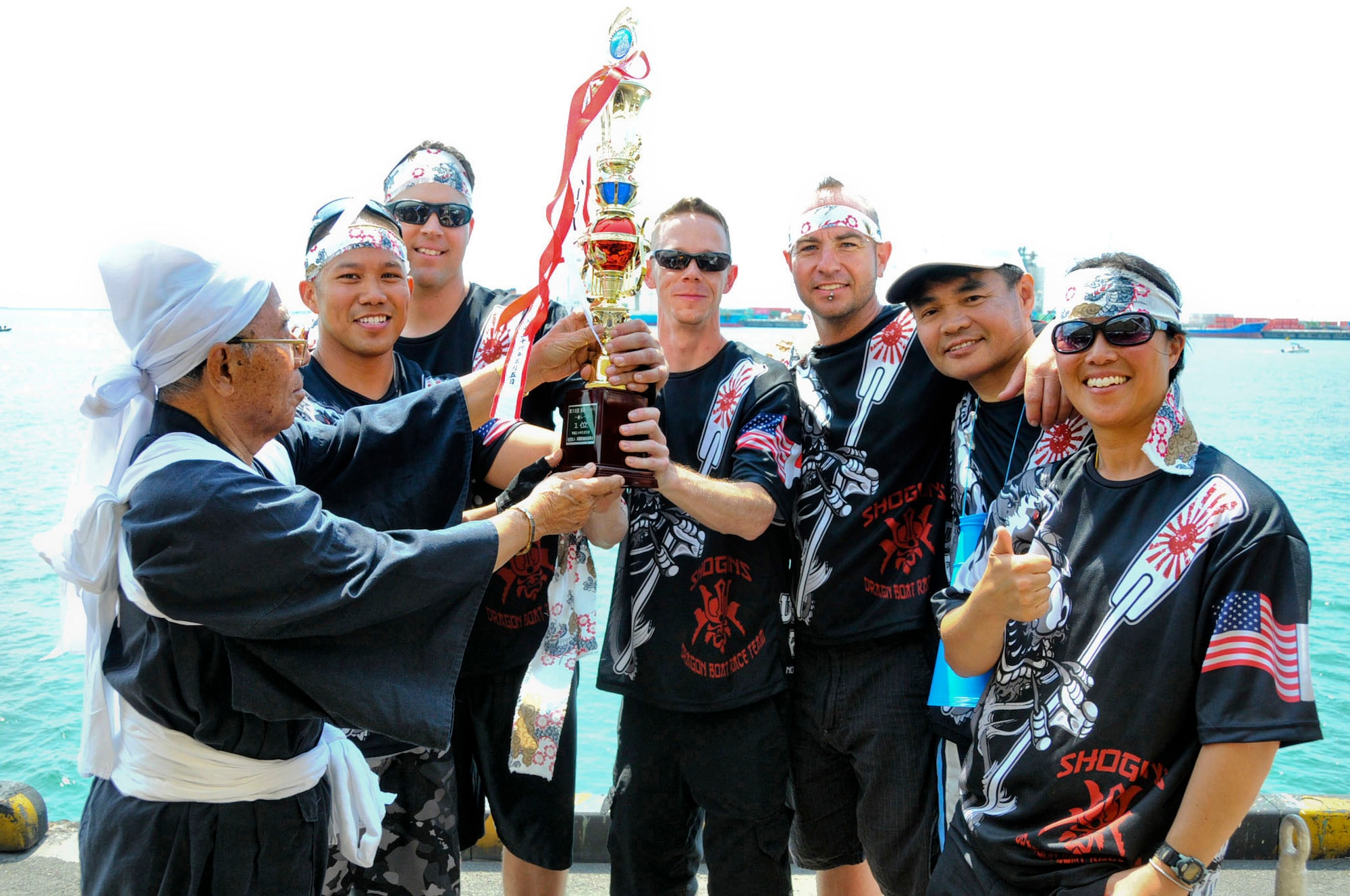 The Kadena Shogun men's team receives their first place trophy from the Naha Dragon Boat Race chairman Masaharu Minei during the 38th Naha Dragon Boat Race at Naha City port, Okinawa, May. 5. The team beat the U.S. Army and Okinawan Airport Services teams with the third fastest overall time advancing the Kadena team to the final round for the first time in 18 years. (U.S. Air Force photo/Staff Sgt. Darnell T. Cannady)  