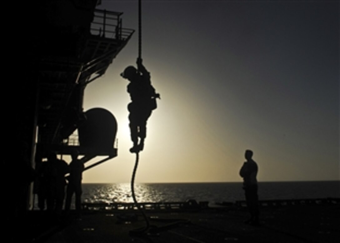 A U.S. Marine assigned to the 11th Marine Expeditionary Unit fast ropes from the back of a helicopter onto the aircraft elevator of the USS Makin Island in the Arabian Sea, May 4, 2012. The Makin Island is deployed in support of maritime security operations and theater security cooperation efforts in the U.S. 5th Fleet area of responsibility.