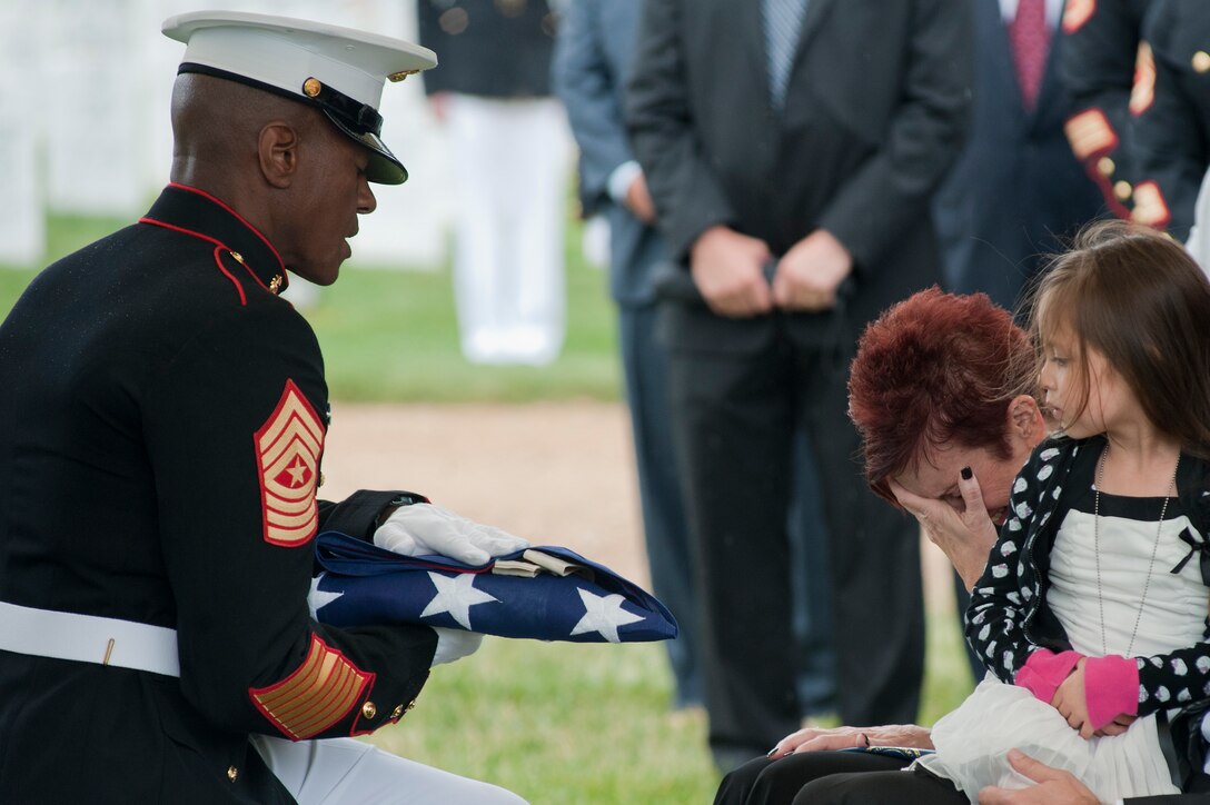 Sgt. Maj. Eric Stockton, Marine Barracks Washington sergeant major, presents a folded flag to Lydia Hobson, the mother of Master Sgt. Scott E. Pruitt, a financial resource management analyst, during his funeral at Arlington National Cemetary May 8. Pruitt died from an improvised explosive device attack during combat maneuvers in Afghanistan, April 28. He was the first Marine in his job specialty to die in combat in Corps history.