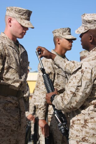 Capt. Lambrato Mathurin, follow series commander, Company B, 1st Recruit Training Battalion, inspects Recruit Alex Bauer, Platoon 1035, Co. B, 1st RTBn., M-16 A4 service rifle April 9 aboard Marine Corps Recruit Depot San Diego. Co. B recruits spent a week cleaning their weapons, preparing their desert combat utility uniforms and reviewing Marine Corps knowledge they had learned so far at recruit training.