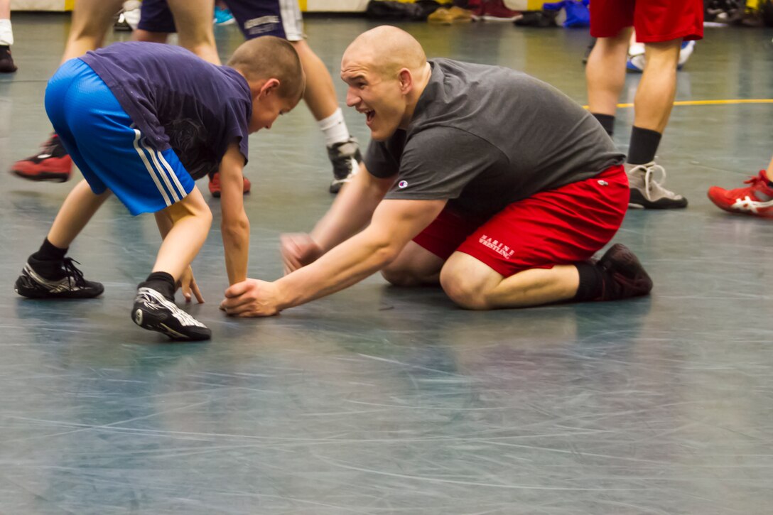 All Marine Wrestling Team member Cpl. Donald Simmons takes on a young wrestler during a Marine led wrestling clinic at St. Edward High School, May 8. St. Edward, the host school of the event, has one of the best wrestling programs in the country, boasting 16 state championships and 11 national championships