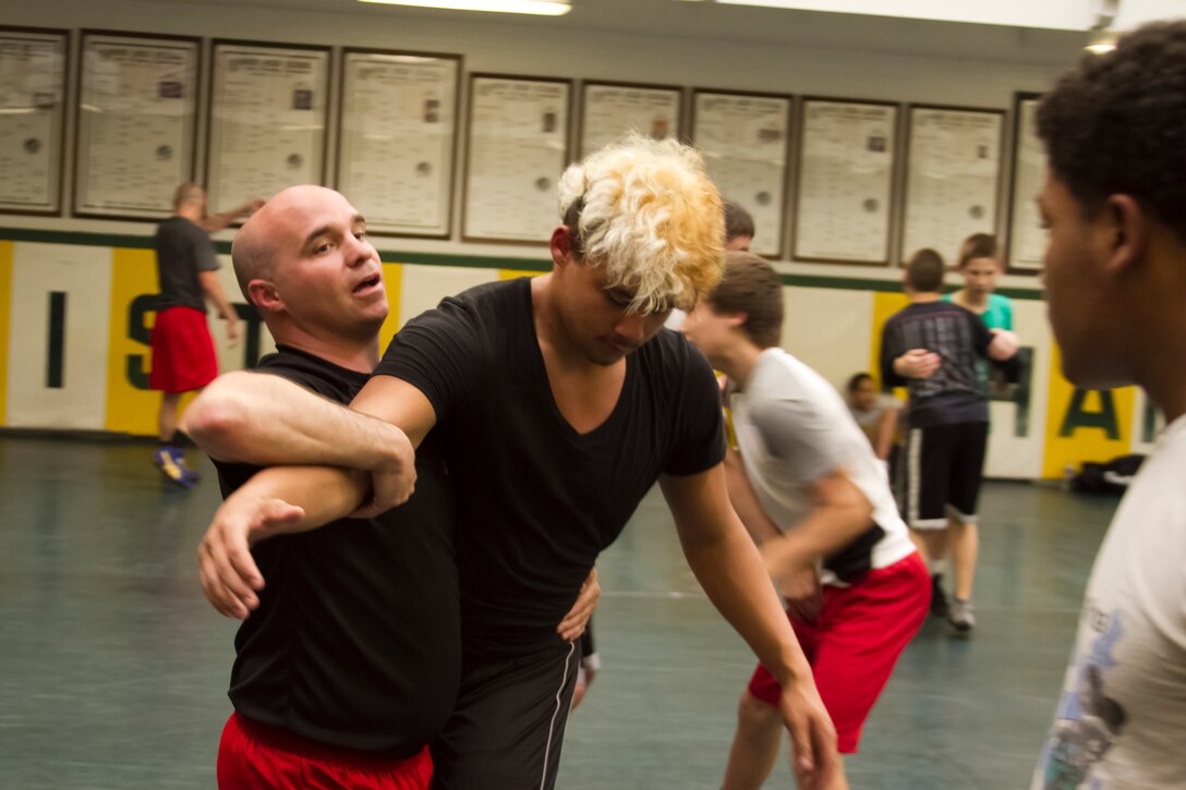 Staff Sgt. Jesse Clark, canvassing recruiter, recruiting substation Lakewood, shares some of his wrestling knowledge with Cleveland area youths during the All-Marine Wrestling Team's clinic at St. Edward High School, May 8. Clark was the Ohio high school state champion the 125 pound division in 1996.