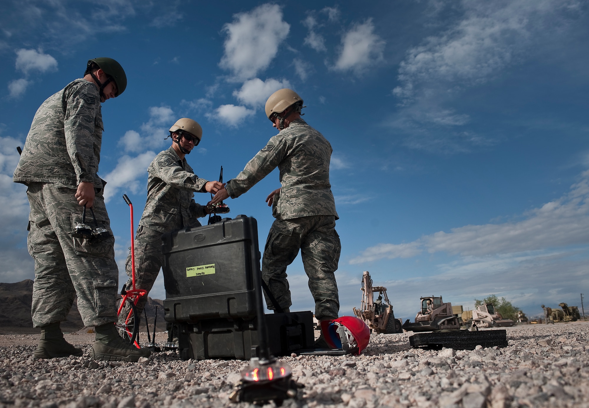 U.S. Air Force Staff Sgt. Steven Land, 820th RED HORSE Squadron airborne flight electrician, along with Staff Sgt.Jesse Hubbard and Staff Sgt. Daniel Franklin, 820th RED HORSE Squadron airborne flight power production craftsmen prepare to light the airfield with phantom lights during a training mission at a simulated flightline April 26, 2012, at Nellis Air Force Base, Nev. Airmen of the 820th RED HORSE Squadron conduct forward operating base construction, force protection build-up, and infrastructure assessment and repair. (U.S. Air Force photo by Staff Sgt. Christopher Hubenthal)