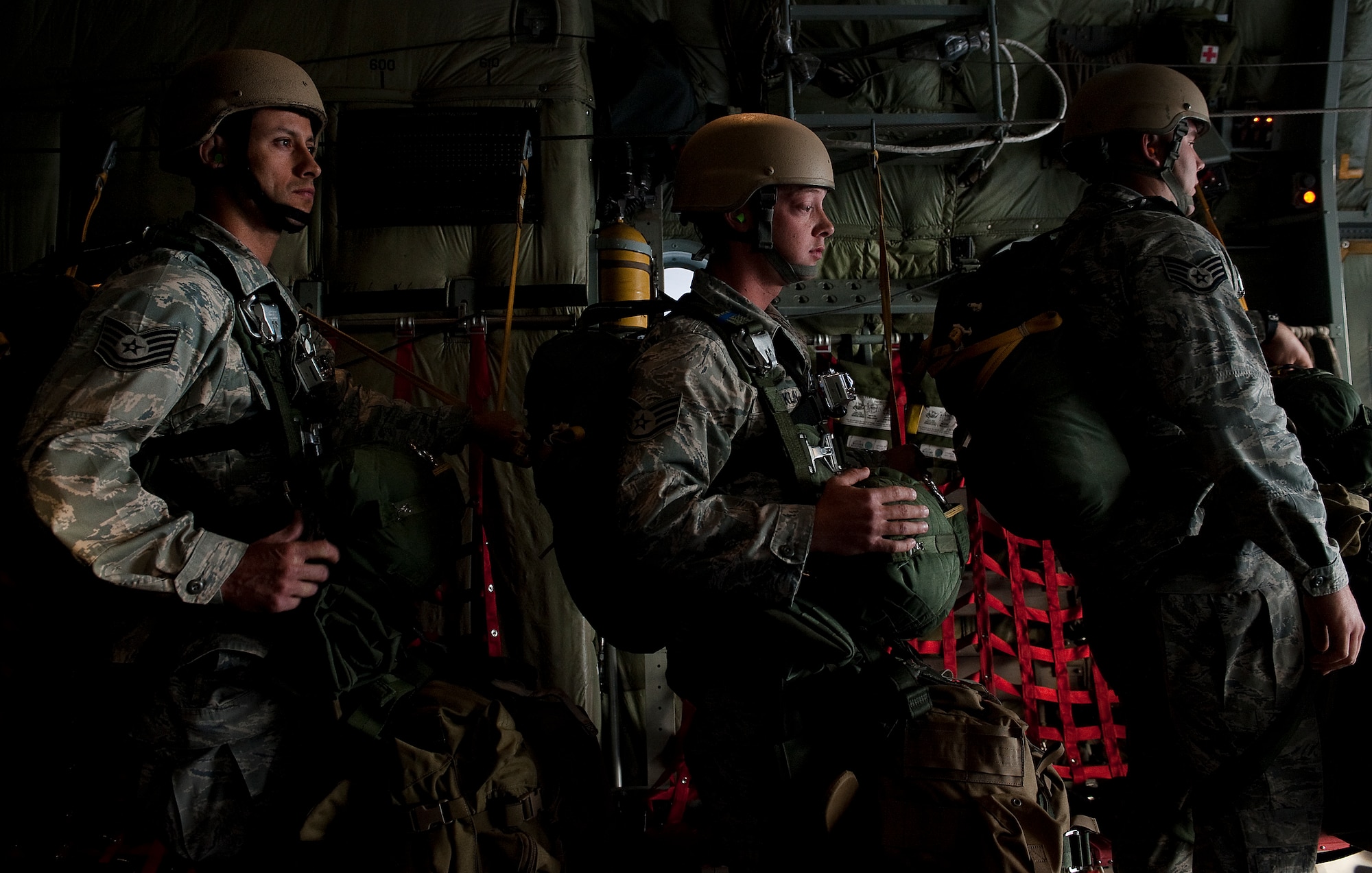 U.S. Air Force Tech. Sgt. Filipe Lucero, Staff Sgt. Daniel Franklin, and Staff Sgt. Jeffrey Madden, 820th RED HORSE Squadron airborne flight, prepare to conduct a static line training jump from a Wyoming Air National Guard C-130 Hercules April 26, 2012, at Nellis Air Force Base, Nev. Airmen of the 820th RED HORSE Squadron train to operate in complex physical, social and informational environments. (U.S. Air Force photo by Staff Sgt. Christopher Hubenthal)
