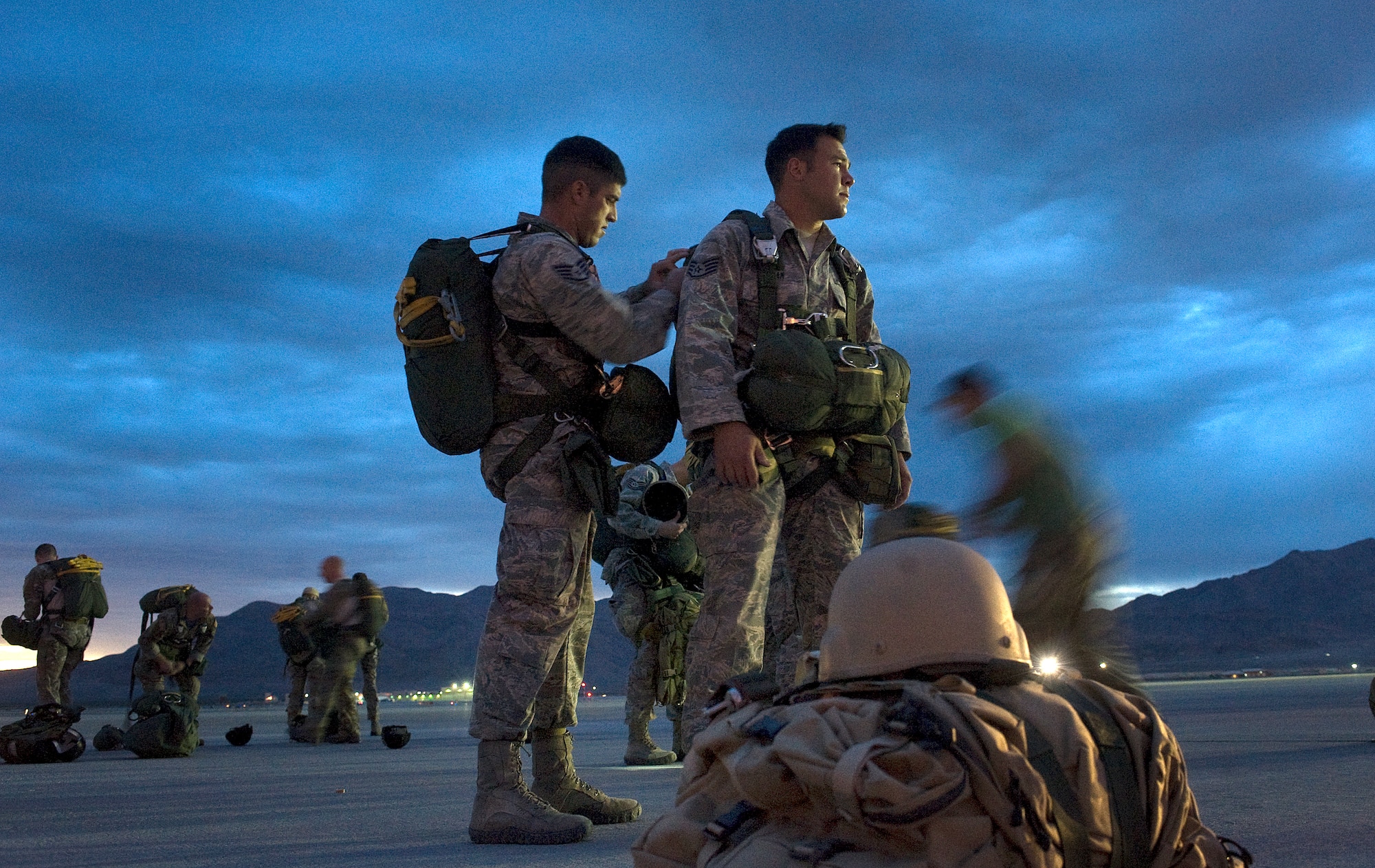 U.S. Air Force Staff Sgt. Troy Hollis, 820th RED HORSE Squadron airborne flight, checks equipment for Staff Sgt. Nick Urban, 820th RED HORSE Squadron airborne flight, prior to a static-line jump mission April 25, 2012, at Nellis Air Force Base, Nev. Ten Airmen of the 820th RHS participated in the static-line jump mission. (U.S. Air Force photo by Staff Sgt. Christopher Hubenthal)