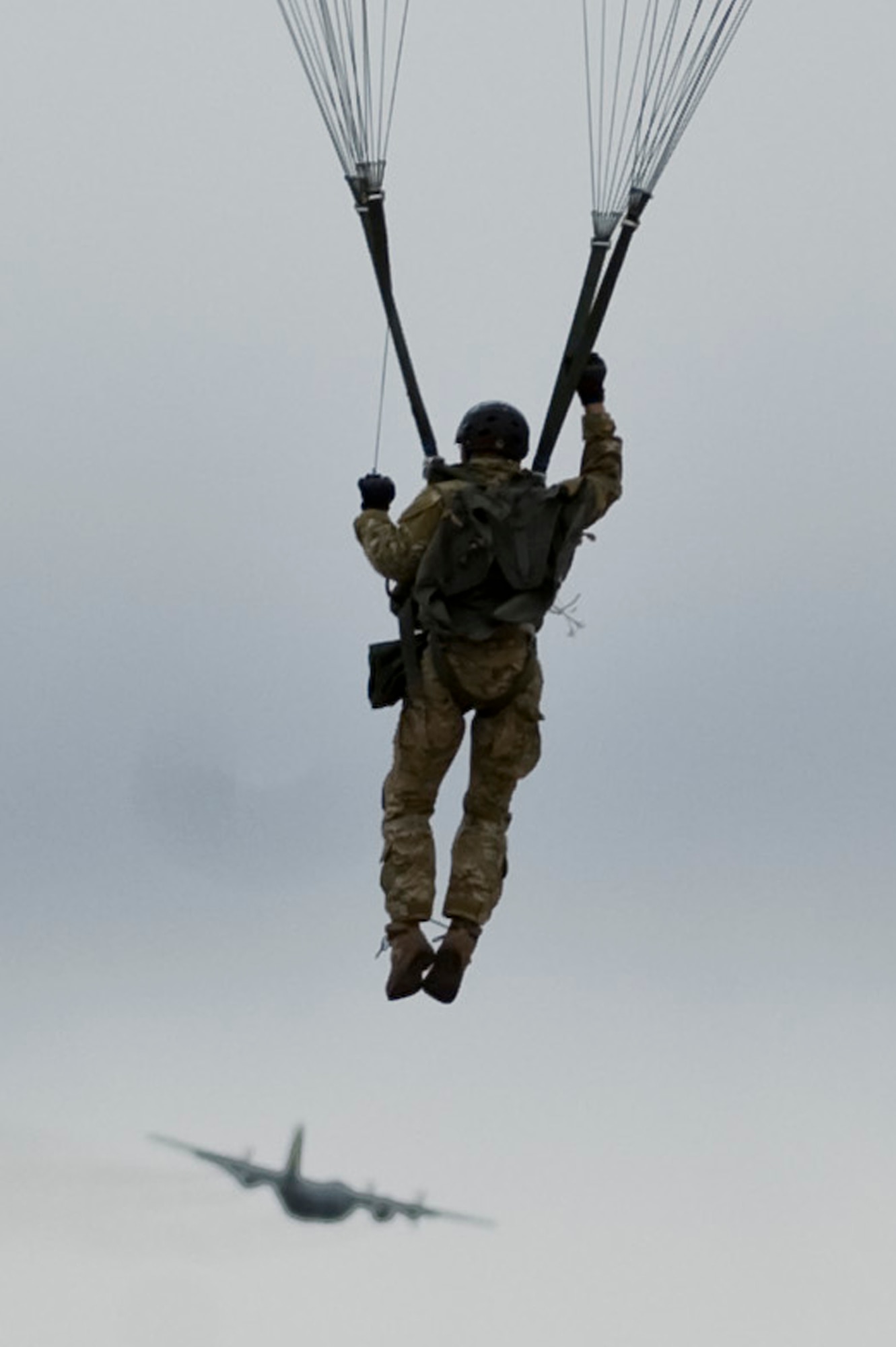 A U.S. Air Force Joint Terminal Attack Controller, prepares to land after a static line jump out of a Wyoming Air National Guard C-130 Hercules, during a training mission, April 25, 2012, at Nellis Air Force Base, Nev. JTACs direct the action of combat aircraft engaged in close air support and other air-to-ground operations.  (U.S. Air Force photo by Airman 1st Class Daniel Hughes)