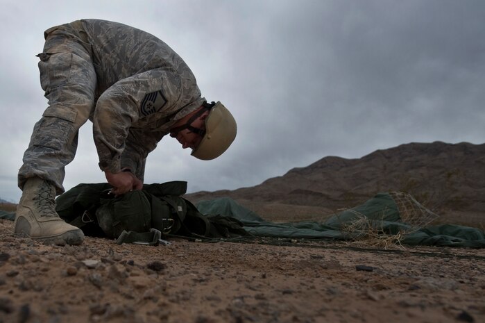 U.S. Air Force Master Sgt. James Ward, 820th RED HORSE Squadron airborne flight member, packs his parachute after landing during a training mission, April 25, 2012, at Nellis Air Force Base, Nev. The primary RED HORSE tasking in peacetime is to train for contingency and wartime operations. (U.S. Air Force photo by Airman 1st Class Daniel Hughes)