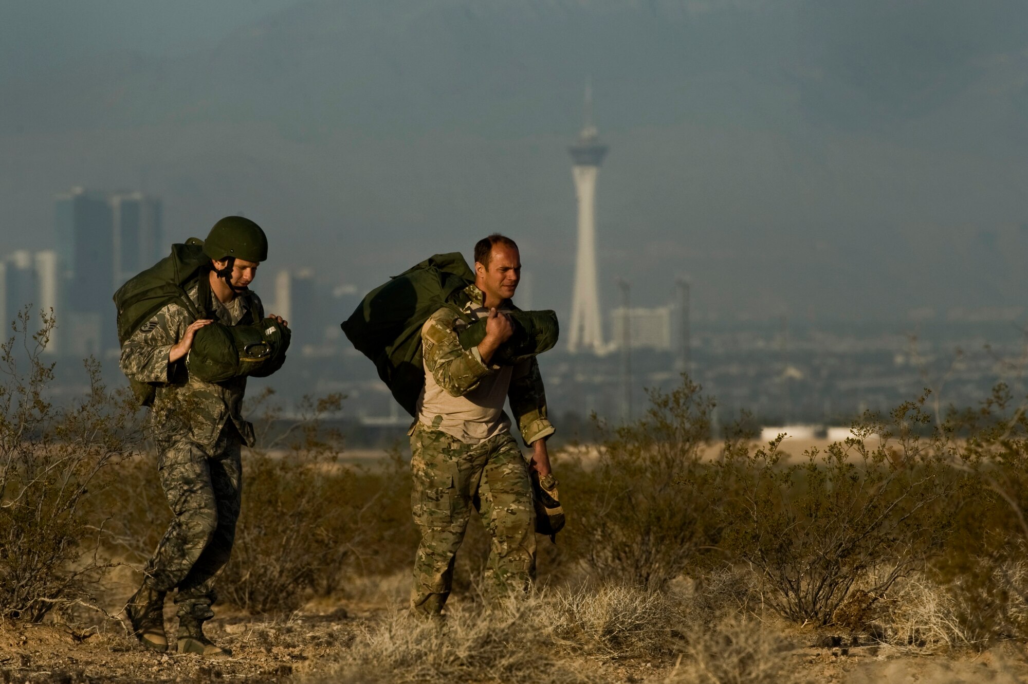 U.S. Air Force Master Sgt. Eric Muller, 6th Combat Training Squadron joint terminal attack controller instructor, and U.S. Air Force Staff Sgt. Ian Zerby, 820th RED HORSE Squadron airborne flight member, ruck back to the designated landing zone during a training mission, April 24, 2012, at Nellis Air Force Base, Nev. RED HORSE airmen perform airdrop missions to stay current on training and certifications, which enables them to perform jump missions and operate their own drop zones. (U.S. Air Force photo by Airman 1st Class Daniel Hughes)
