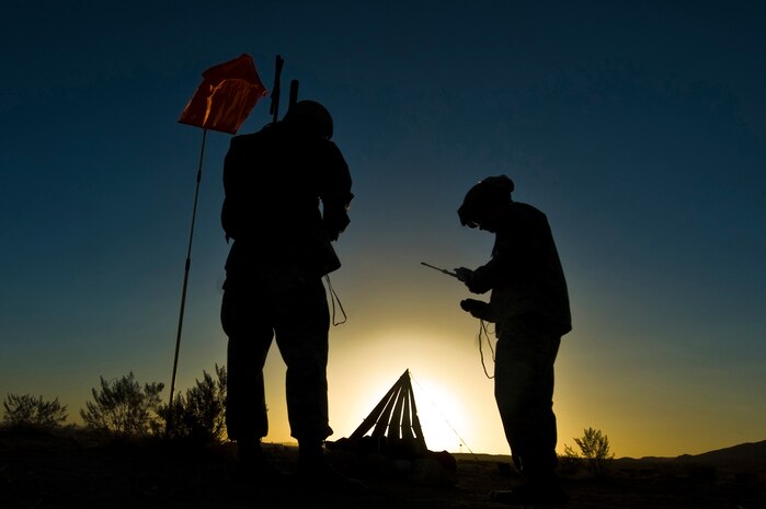 U.S. Air Force Staff Sgt. Sean McCarty, 820th RED HORSE Squadron airborne flight firefighter, and Tech. Sgt. Kellen Buss, water and fuels systems maintenance craftsman, check radio frequencies during a training mission, April 24, 2012, at Nellis Air Force Base, Nev. RED HORSE added an airborne capability in 2005. (U.S. Air Force photo by Airman 1st Class Daniel Hughes)
