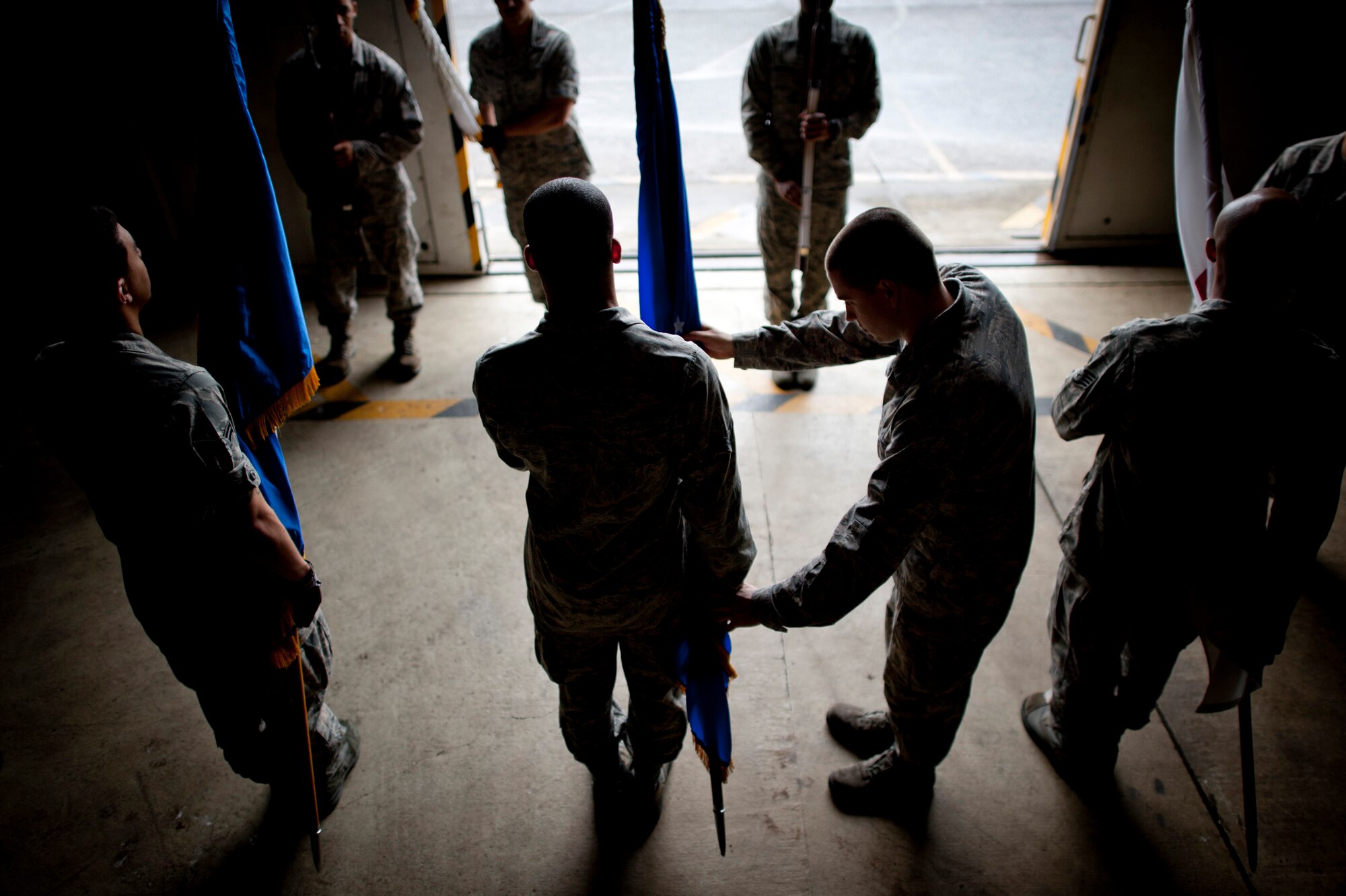 YOKOTA AIR BASE, Japan -- Airman 1st Class William Johnson, Yokota Honor Guardsman, assists recruits with placing the flag staffs in the correct position of present arms during a training session at Yokota Air Base, Japan, May 3, 2012. (U.S. Air Force photo by Staff Sgt. Samuel Morse)