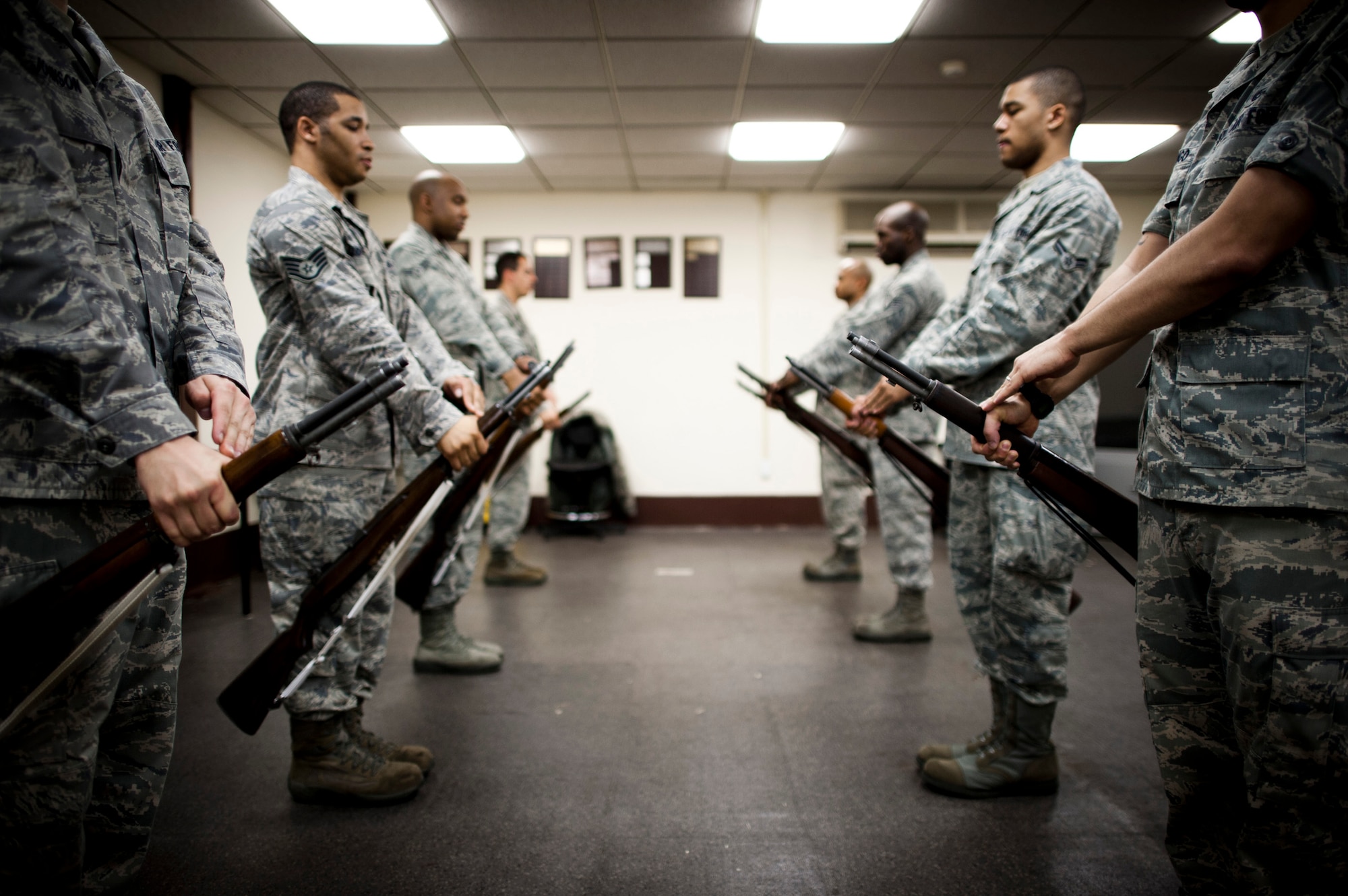 YOKOTA AIR BASE, Japan -- Yokota Honor Guardsmen, left, teach new recruits the steps for performing the order arms movement during a training session at Yokota Air Base, Japan, May 2, 2012. Honor guardsmen train "by the numbers" which means pausing for each move and shouting out the movement count before proceeding to the next position. (U.S. Air Force photo by Staff Sgt. Samuel Morse)