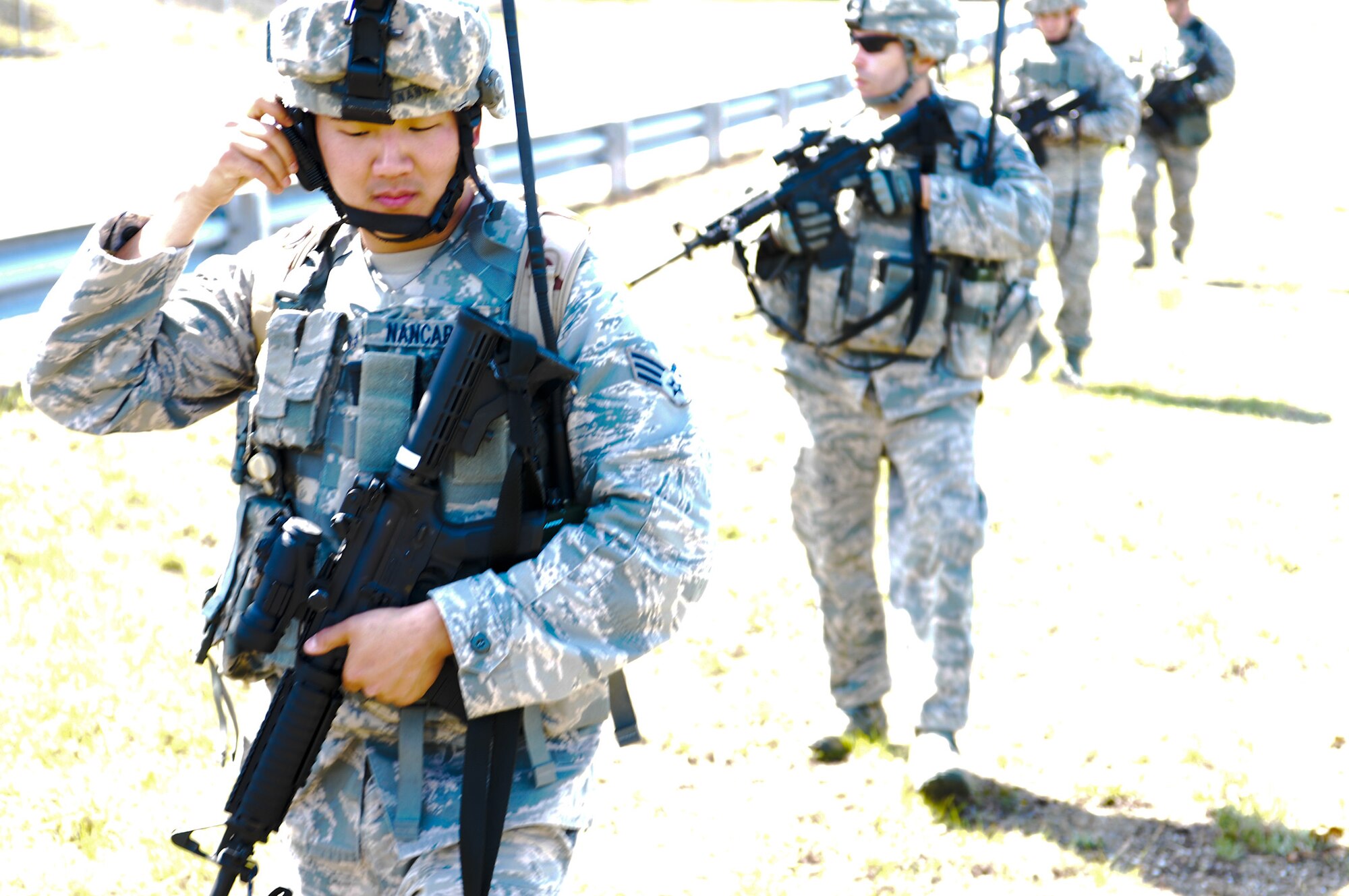 Senior Airman Allen Nancarrow, 102nd Security Forces Squadron, monitors radio frequencies as his fire team scans their sectors during the dismounted patrol portion of their annual combat readiness task training on Otis Air National Guard Base May 7, 2012. The 102 SFS defenders were tasked with locating and navigating their way to five checkpoints on Otis ANGB while moving tactically in formations.  The 102 SFS defenders spent the day honing their skills in areas such as convoy operations and dismounted patrol procedures in order to keep their proficiency at a high level. (U.S. Air Force photo/ Senior Airman Patrick McKenna)