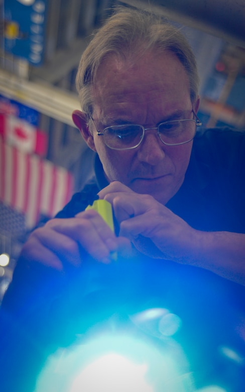 David Geyer uses a flashlight, mirrors and identification tags to inspect an F-117 engine at Joint Base Charleston – Air Base May 3. Once an issue is found on the engine, Geyer uses a tag to identify the specific area. Geyer is a United Airlines F-117 engine inspector. (U.S. Air Force photo/Airman 1st Class Dennis Sloan)