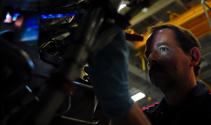 Jerry Zuk uses a flashlight and a mirror to inspect insulation of electrical lines on an F-117 engine at Joint Base Charleston – Air Base May 3. Zuk spends several hours looking at everything from metal pipes, steel fan blades to electrical wires and insulation to make sure the engine meets all of its specifications. The engine will be used on a C-17 Globemaster III once it passes inspection, testing and is certified. Zuk is a United Airlines F-117 engine inspector. (U.S. Air Force photo/Airman 1st Class Dennis Sloan)