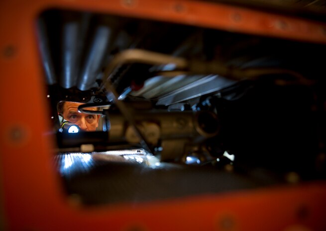 Jerry Zuk uses a flashlight to illuminate a small space, which contains key parts to the F-117 engine at Joint Base Charleston – Air Base May 3. Zuk performs several inspections on the engine while it is being built. The F-117 Engine, when completed and having passed testing, will be installed on a C-17 Globemaster III. Zuk is a United Airlines F-117 engine inspector. (U.S. Air Force photo/Airman 1st Class Dennis Sloan)