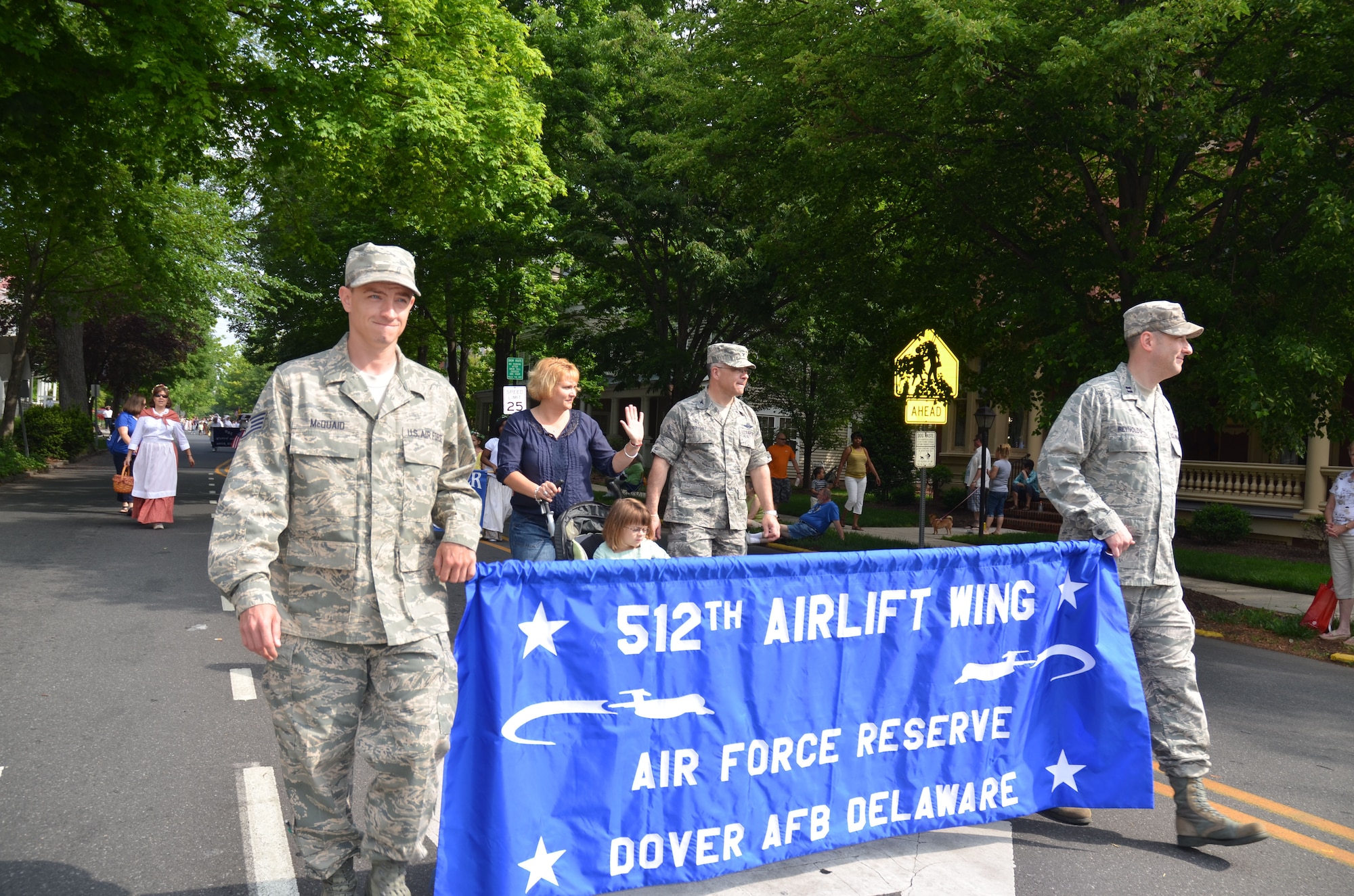 Staff Sgt. Shawn McQuaid (left) and Capt. Jeremy Reynolds lead 512th Airlift Wing Commander Col. Randal L. Bright and his family along a parade route in downtown Dover, Del., May 5, 2012, during the annual Dover Days Festival.  The three-day event celebrated the diversity, traditions and talents of the residents of the city and its 329-year history. McQuaid is a fuels operations specialist with the 512th Logistics Readiness Squadron, while Reynolds is executive officer of the 512th Mission Support Group. They and Bright represented the Air Force Reserve wing during the celebration, which was attended by more than 35,000 people.