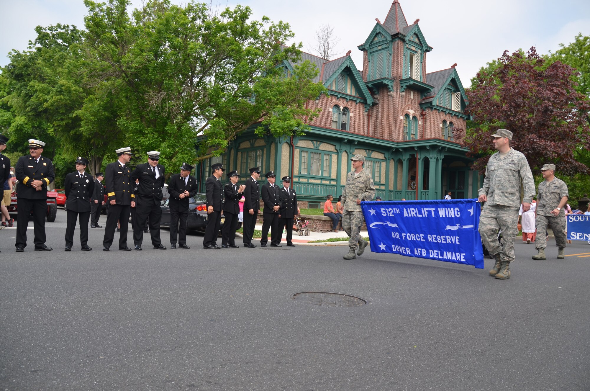 Members of the Dover, Del., Fire Department greet 512th Airlift Wing representatives May 5, 2012, during a parade in the 78th Annual Dover Days Festival. Leading Wing Commander Col. Randal L. Bright (far right) are Staff Sgt. Shawn McQuaid (left), a fuels operations specialist from the 512th Logistics Readiness Squadron, and Capt. Jeremy Reynolds, executive officer of the 512th Mission Support Group. The three-day event drew 35,000 people to celebrate the diversity, traditions and talents of the residents of the 329-year-old city.