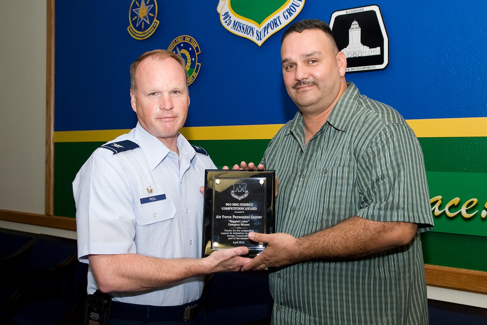 Ruben Gomez, Air Force Personnel Center facility operations chief, recieves the biggest loser award from Col. Scott Peel, 902nd Mission Support Group commander, May 7 concluding a base-side energy conservation competition at Joint Base San Antonio-Randolph, Texas. (U.S. Air Force photo by Benjamin Faske)