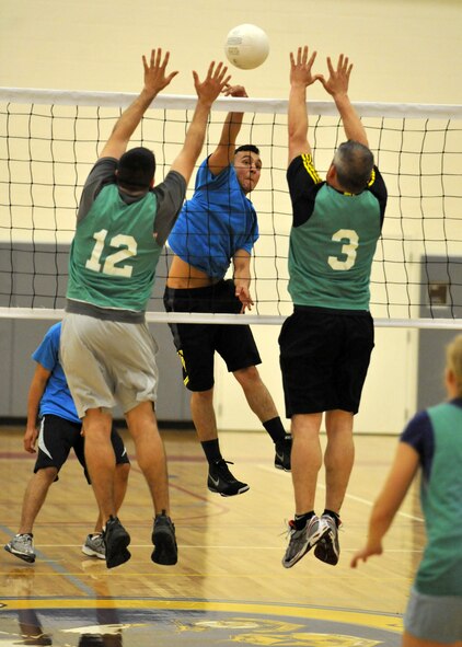 Eric Heyden of the 436th Maintenance Squadron attempts to slam home a kill against members of the 436th Operations Group during an intramural volleyball match May 8, 2012, at the Fitness Center on Dover Air Force Base, Del. The 436th MXS came back to win the match 15-25, 25-21 and 15-11. (U.S. Air Force photo by Tech. Sgt. Chuck Walker)