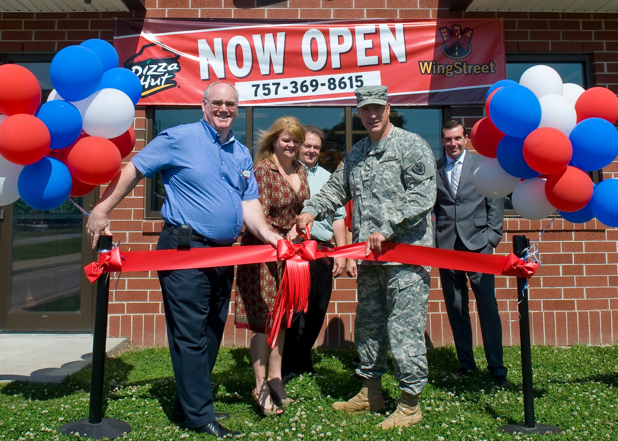 U.S. Army Col. Thomas Wetherington, 733rd Mission Support Division commander, cuts the ceremonial ribbon at the "grand opening" of the new Pizza Hut restaurant at Fort Eustis, Va., May 8, 2012. The restaurant opened its doors to customers May 1 at its location adjacent to the Eustis Community Recreation Center. (U.S. Air Force photo by Senior Airman John D. Strong II/Released)