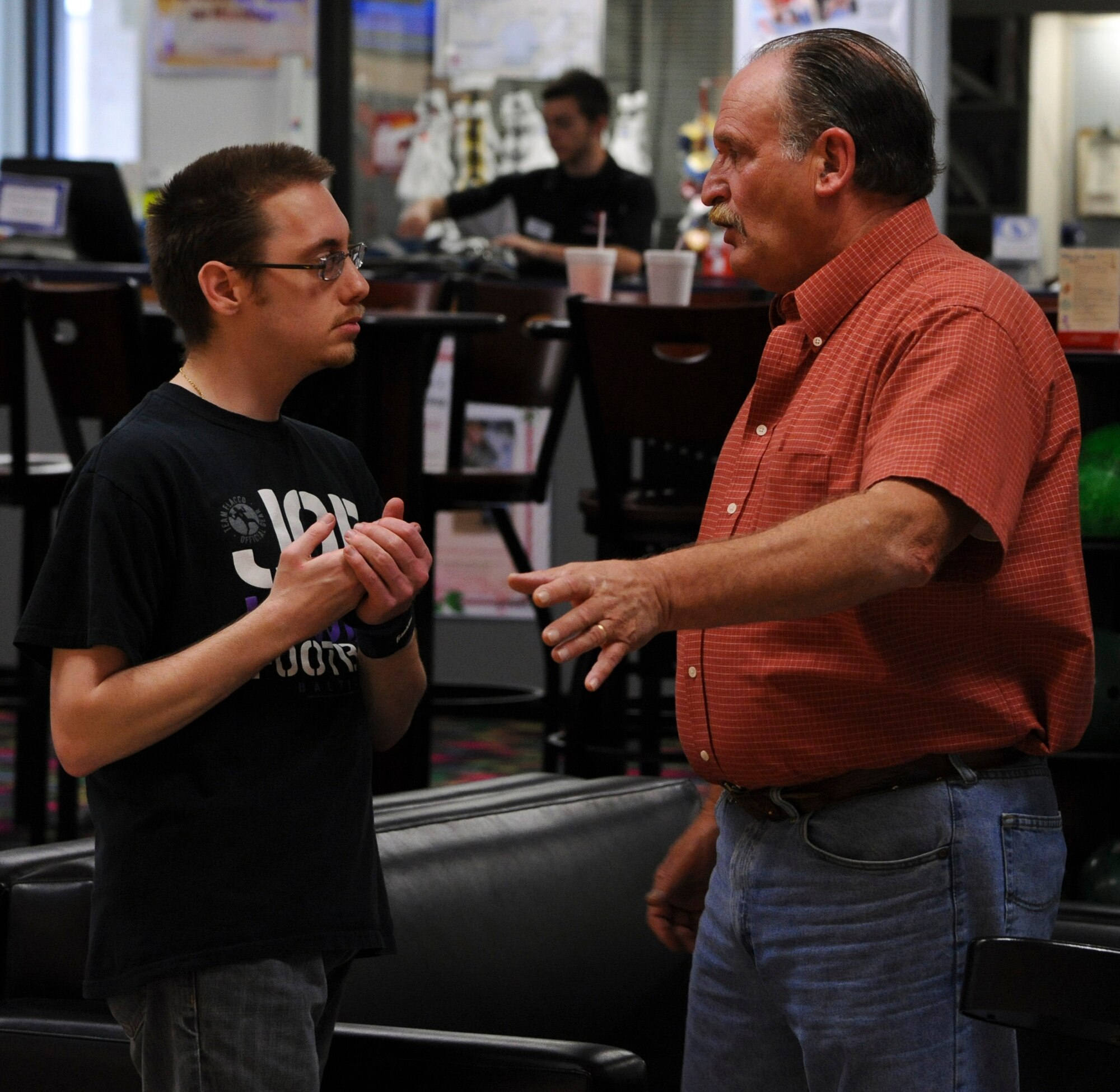 Nick Ferri, right, secretary of the "Can Doers Bowling League," gives bowling advice to Marc Matague May 5, 2012, during a league game at the Eagle Lanes Bowling Center on Dover Air Force Base, Del. The "Can Doers Bowling League" is comprised of military dependants who have intellectual or physical disabilities. The "Can Doers Bowling League" is an open league with a flexible schedule allowing members to enter the league at any time, or miss a game without penalty. (U.S. Air Force photo by Senior Airman Matthew Hubby)
