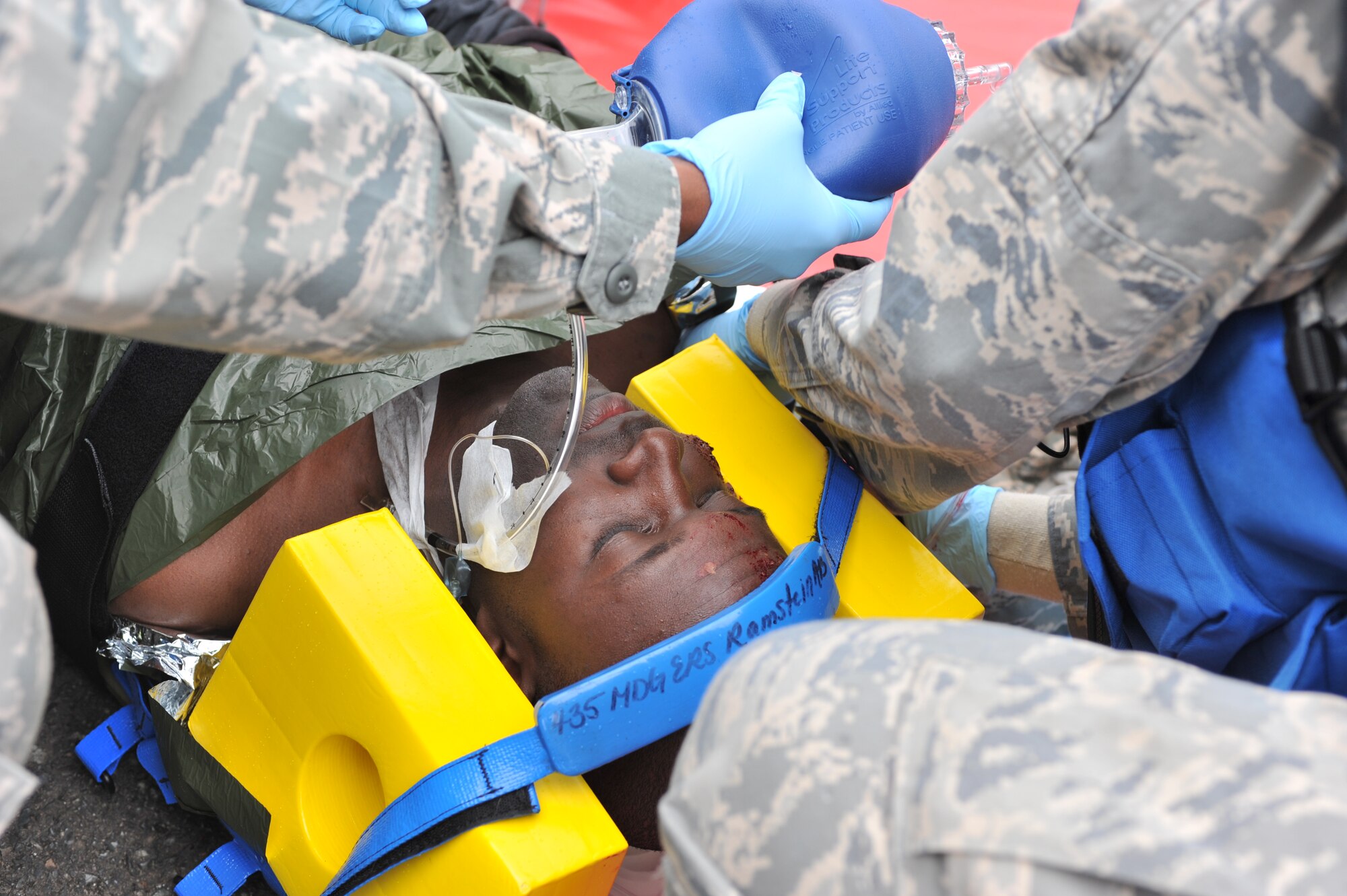 Maj. Gary Cooper, a simulated victim, is tended to by medical personnel while they respond to an operational readiness exercise scenario on Ramstein Air Base, Germany, May 5, 2012. The ORE incorporates a series of scenarios used to evaluate a base's ability to execute operational duties while responding to various crises. (U.S. Air Force photo/Senior Airman Caitlin O’Neil-McKeown)