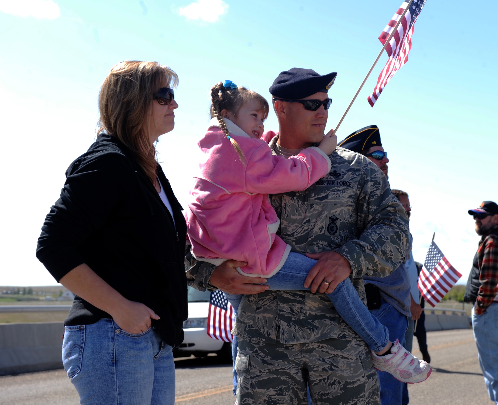 U.S. Air Force Master Sgt. Brian Wilson, 366th Security Forces Squadron, along with his wife Heather and his daughter Courtney await the arrival of a funeral procession for Army Sgt. Chris Workman in Mountain Home, Idaho, May 2, 2012. Workman, 33, lost his life in a UH-60 Black Hawk crash while performing a mission to save a wounded Afghan police officer. (U.S. Air Force photo/ Airman 1st Class Jonathan Glanville)
