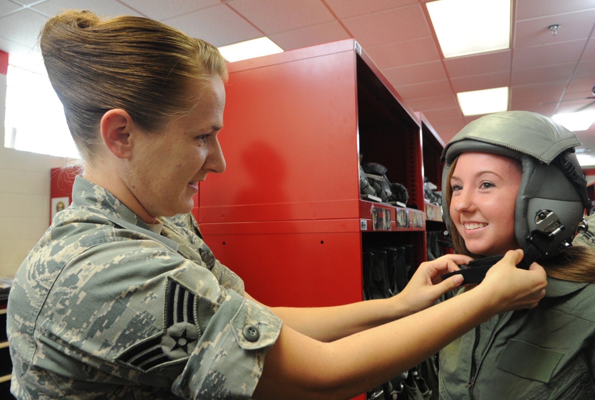 U.S. Air Force Senior Airman Angela Tobin fits Jessica Clingerman in a Gentex HGU-55/P flyer’s helmet prior to an F-15-E Strike Eagle taxi ride on Seymour Johnson Air Force Base, N.C., May 4, 2012. Spouses of 333rd Fighter Squadron and Aircraft Maintenance Unit Airmen were given the opportunity to take a taxi ride as appreciation for the support they provide to their husbands and wives. Tobin, 4th Operations Support Squadron aircrew flight equipment journeyman, hails from Moreno Valley, Calif. Clingerman is the spouse of Staff Sgt. Steven Clingerman a 333rd AMU armament systems technician apprentice from Houghton Lake, Mich. (U.S. Air Force photo/Airman 1st Class Aubrey Robinson/Released)