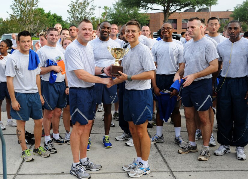 Col. Richard McComb presents the "Most Spirited" trophy to the 628th Logistics Readiness Squadron at the Commander's Run at Joint Base Charleston - Air Base May 4. McComb is the JB Charleston commander. (U.S. Air Force photo/Airman 1st Class Ashlee Galloway)