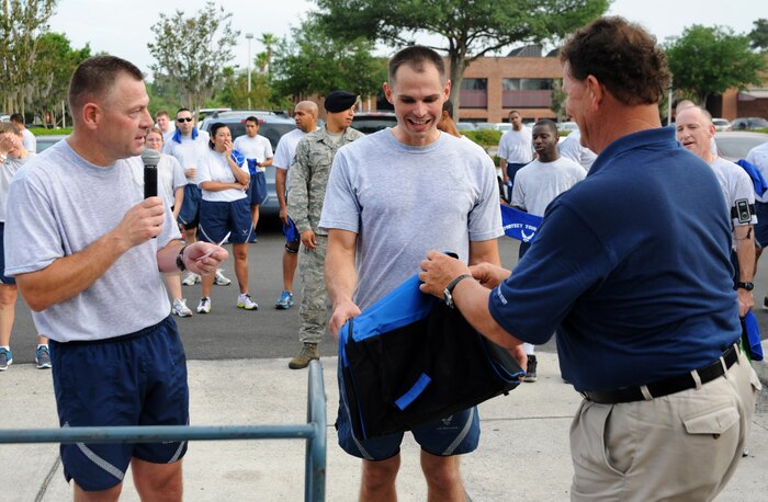 Airman 1st Class Brian Mixsell is presented an award for being the fastest male runner with a time of 11:21 during the 1.96 mile Commander's Run at Joint Base Charleston - Air Base May 4. Mixsell is from the 437th Maintenence Squadron, 437th Airlift Wing. (U.S. Air Force photo/Airman 1st Class Ashlee Galloway)