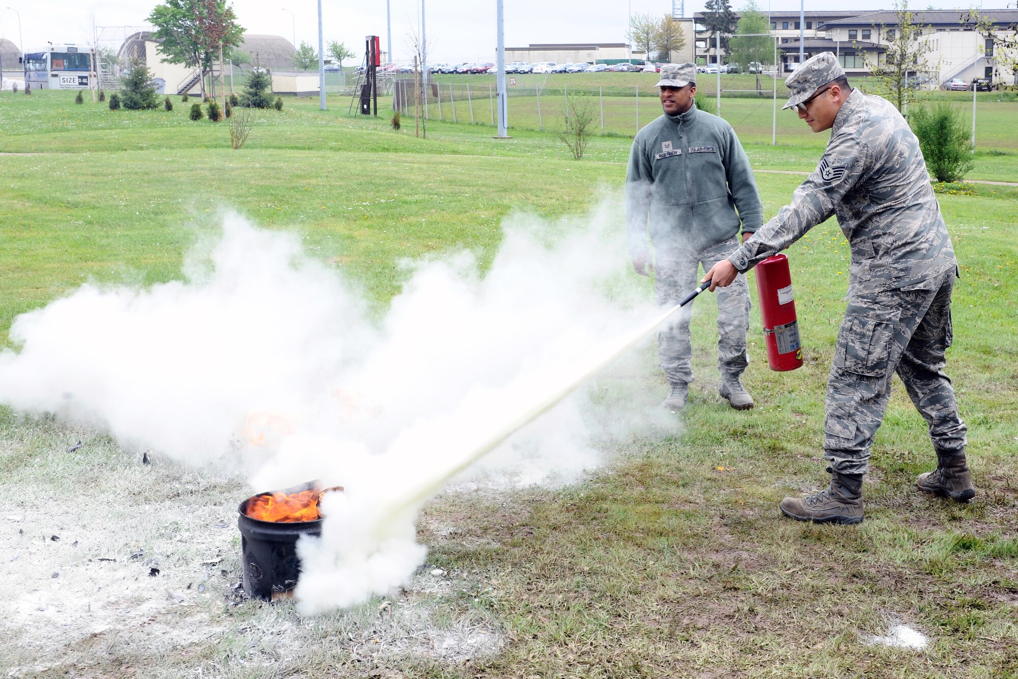 SPANGDAHLEM AIR BASE, Germany – Staff Sgt. Cliff Cooke, 52nd Logistics Readiness Squadron passenger and travel traffic management office craftsmen, extinguishes a fire during individual core competency skills training at the outdoor basketball court here May 7. The training evaluated Airmen on their combat readiness skills such as M-4 assault rifle weapons knowledge; self-aid buddy care; and chemical, biological, radiological, nuclear, and high-yield explosive preparedness. The training ensures the 52nd Fighter Wing is able to provide combat power to the current fight. (U.S. Air Force photo by Airman 1st Class Dillon Davis/Released)