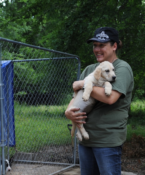 Staff Sgt. Kichelle Rowe, 2nd Medical Group physical therapy technician, holds a puppy in Doyline, La., May 5. Rowe is the co-founder of a non-profit puppy adoption organization that rescues stray puppies from the streets and from local shelters. The organization has placed more than 150 puppies in loving homes since its creation. (U.S. Air Force photo/Airman 1st Class Benjamin Gonsier)(RELEASED)

