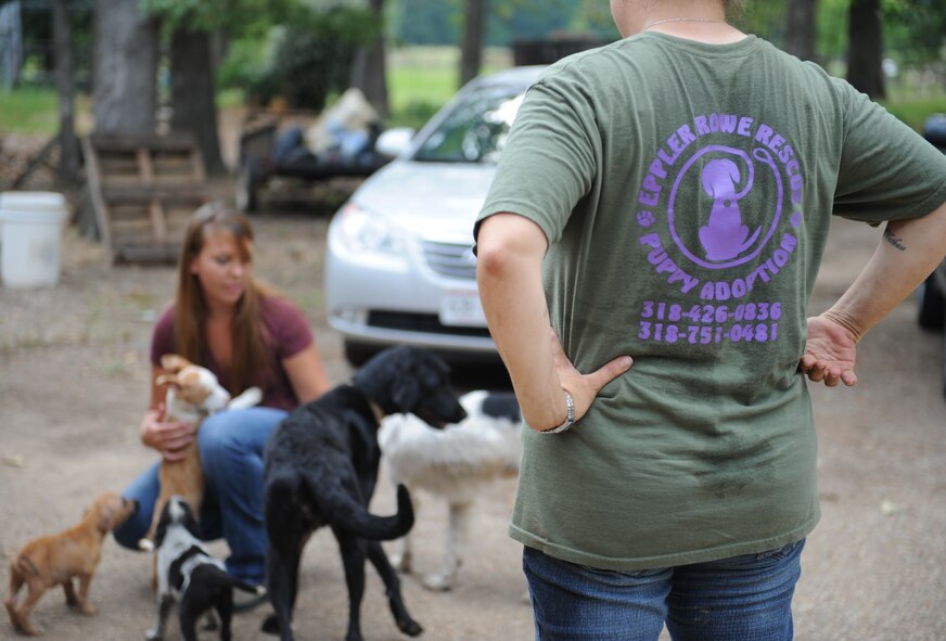 Staff Sgt. Kichelle Rowe, 2nd Medical Group physical therapy technician, watches a Barksdale Airman play with her puppies in Doyline, La., May 5. Rowe, with friend Amanda Eppler, started a non-profit organization that helps rescue stray puppies and puts them up for adoption. (U.S. Air Force photo/Airman 1st Class Benjamin Gonsier)(RELEASED)
